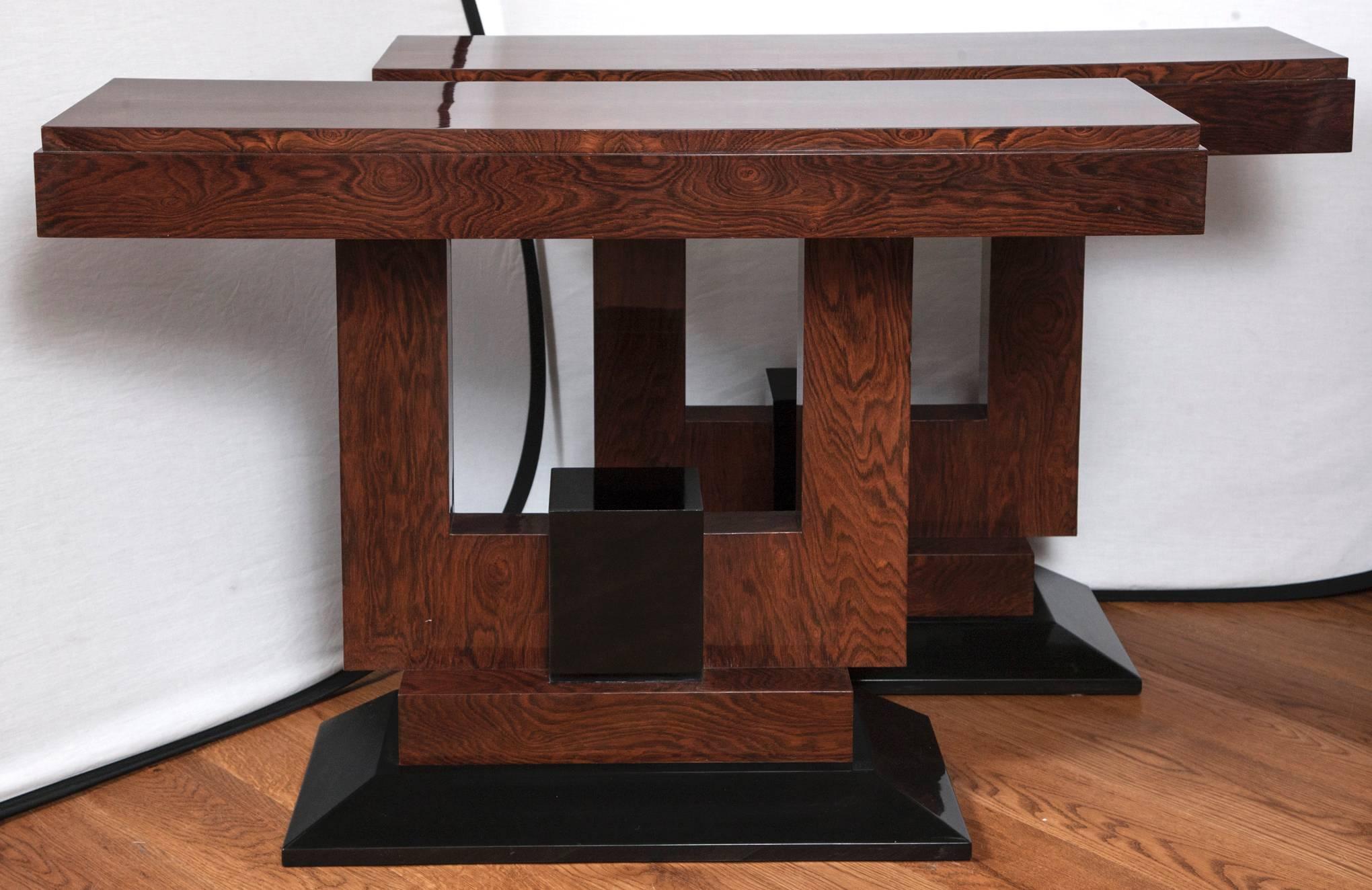 Handsome pair of narrow rectangular stepped platform tables with cubical u-shaped bases in macassar ebony veneer and ebonized detailing, unusual form, dating 1930-1940ca, refurbished and recently French polished
