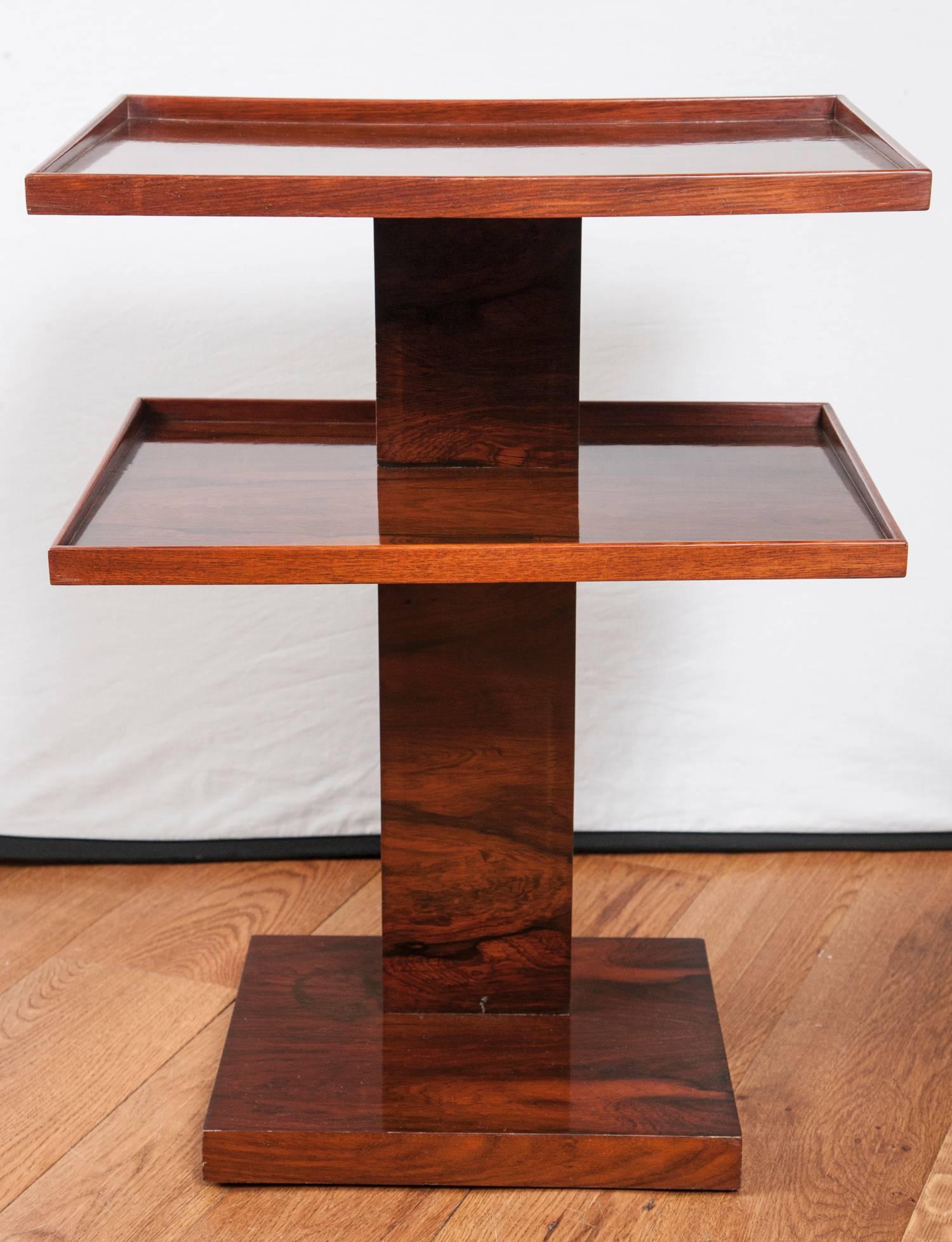 An extraordinary French Arte Moderne étagère table finished on all sides in a rosewood veneer, note sculptural quality and tapering side angles of the upper plateaus, circa 1930.