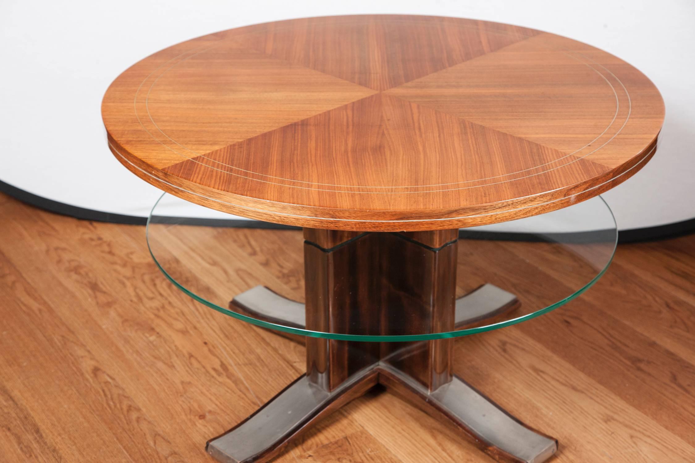 French Art Deco low round table, plateau in a veneered mahogany plateau with brass inlay, a glass shelf below finishing on a sleek mahogany base with steel splayed feet.
Attibuted to De Coene 