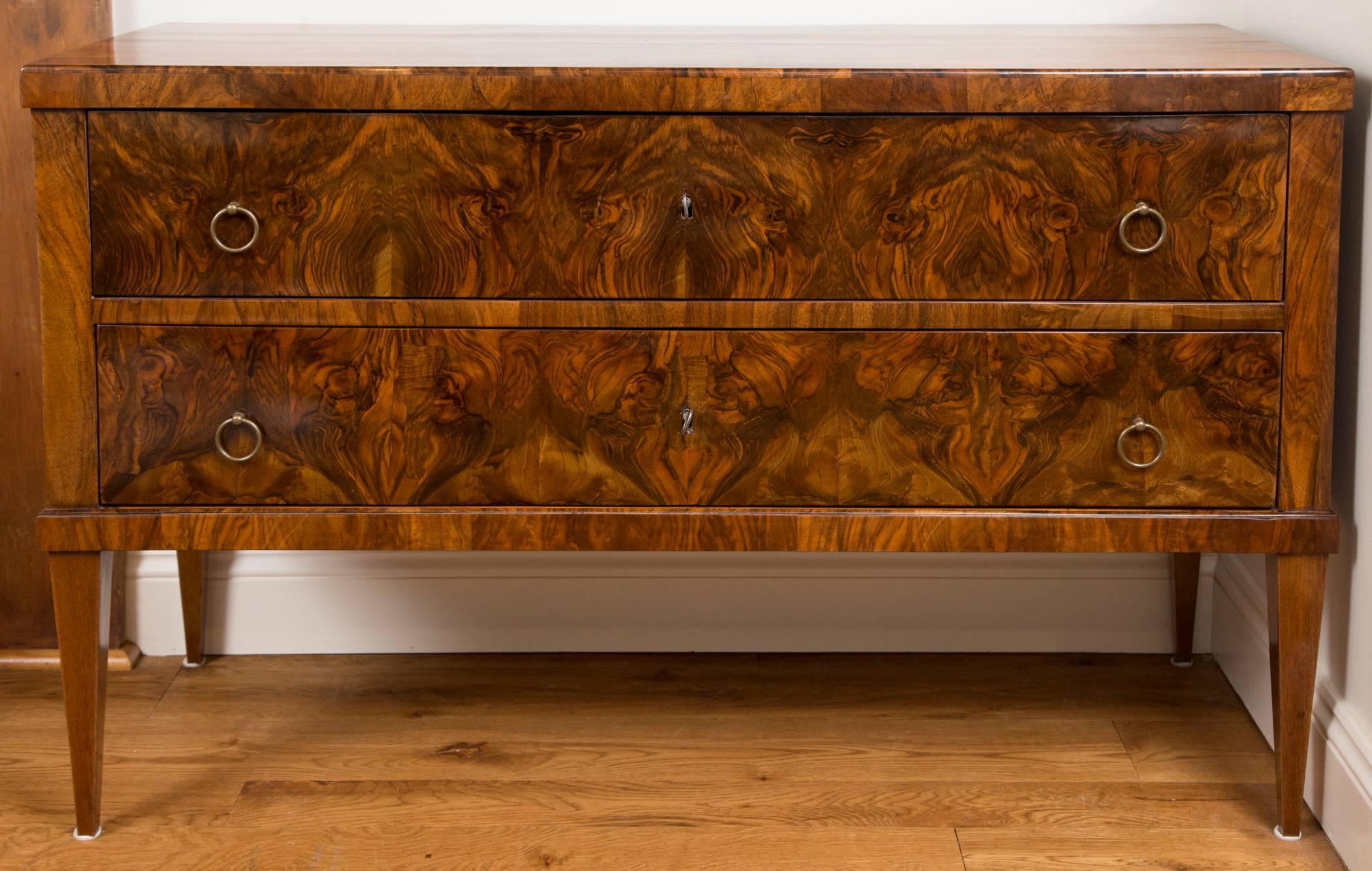 Pair of large Biedermeier chests comprised of two long drawers with brass pulls finishing on high tapered legs,  bookmatched burl walnut veneer on pine,  refurbished and French polished.
 
 