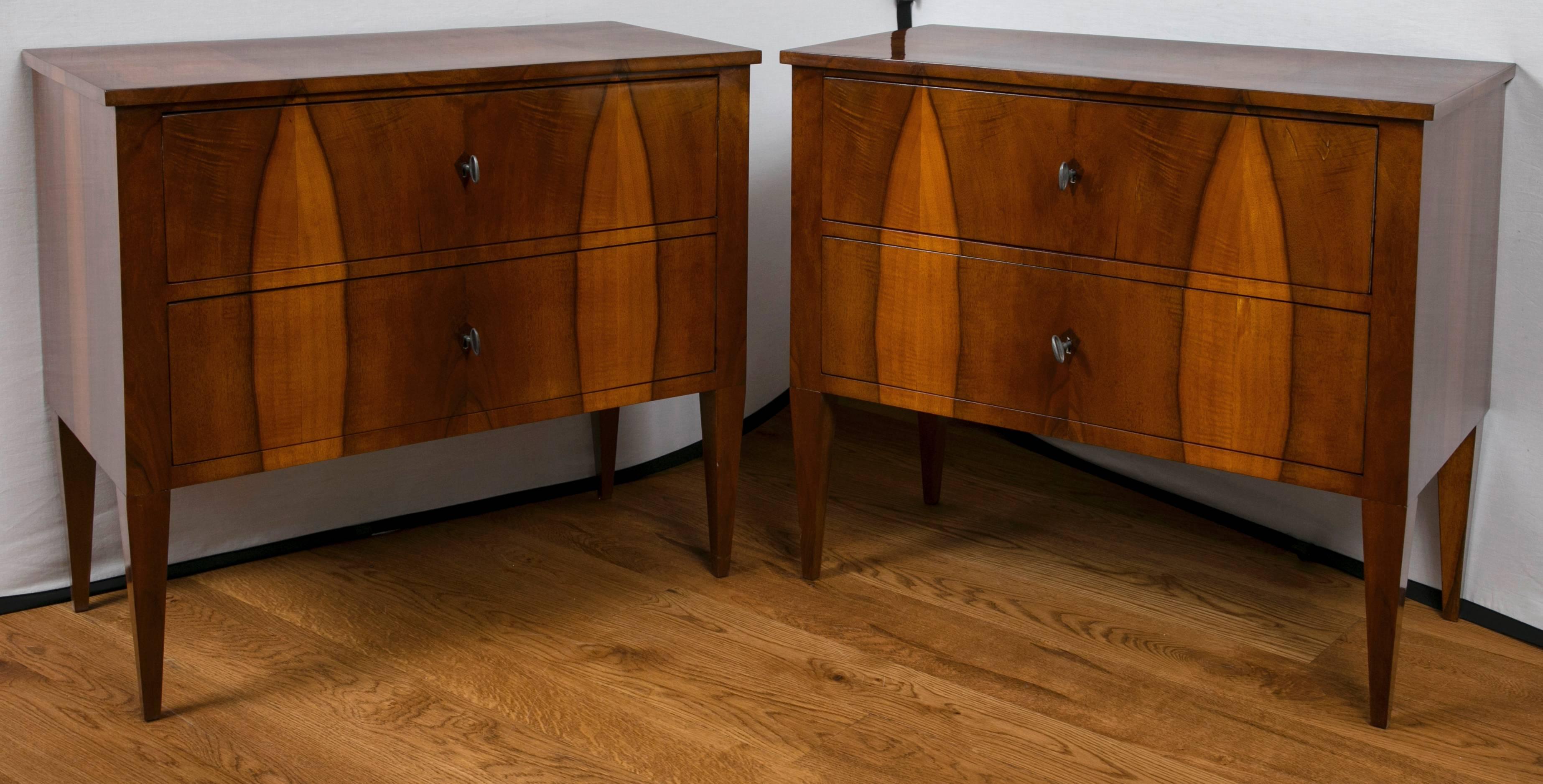 Pair of Biedermeier style chests comprised of two drawers on high tapered and straight legs with inlaid diamond shaped key holes, primary wood in a beautiful book matched walnut veneer on pine, refurbished and French polished, circa 1860.
