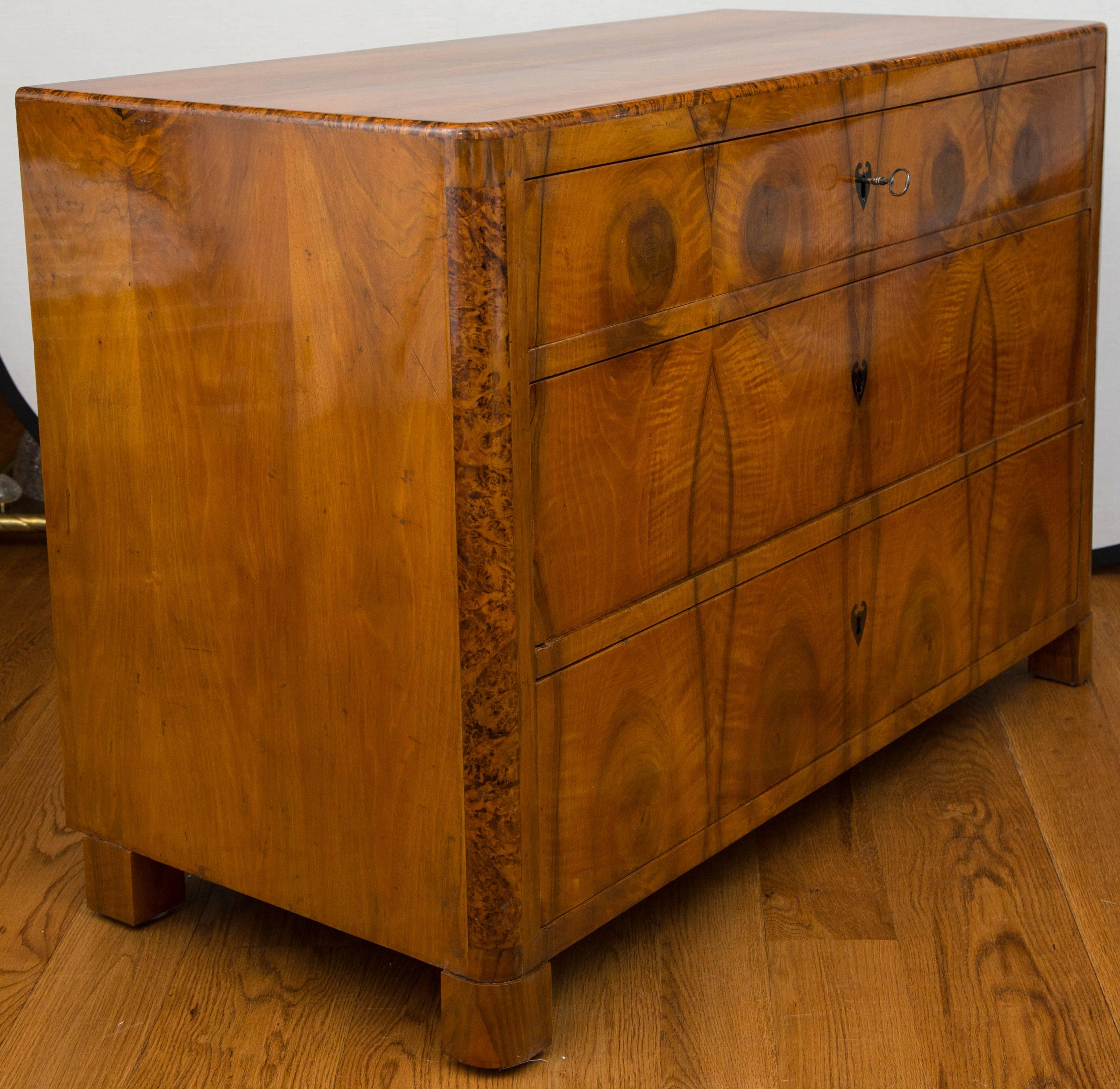 A single Biedermeier three-drawer chest of exceptional quality in walnut and burl wood veneer on pine, inlaid neoclassical escutcheons adorn this lovely facade, shown with original locks.
walnut veneer on pine
Origin: southern Germany.
 