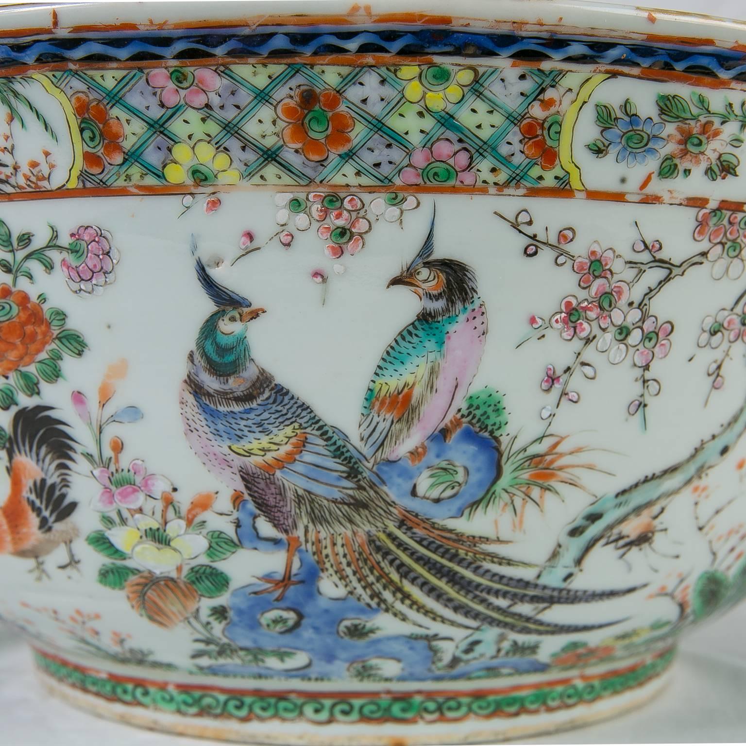 An exceptionally large early 19th century Chinese punch bowl finely painted with auspicious scenes of colorful, luxurious birds including peacocks, roosters and pheasants. 
It is the combination of these colorful scenes which makes this delightful