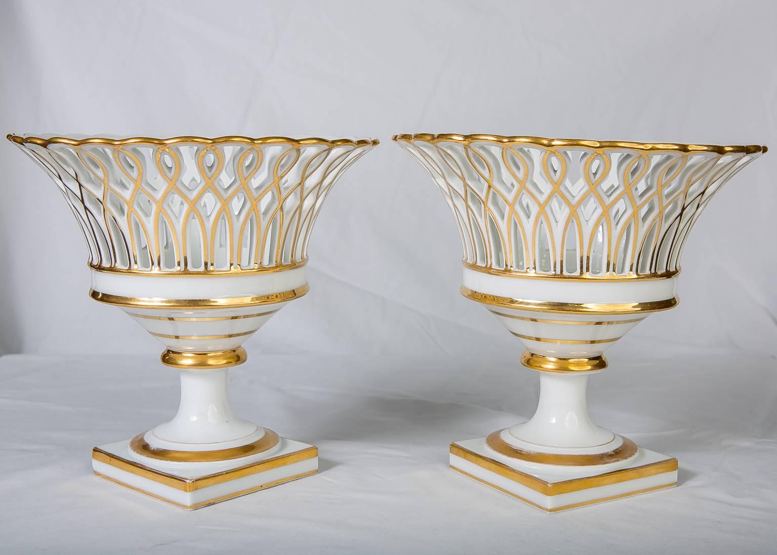 An elegant pair of gilded Paris porcelain pierced baskets with everted rims. They stand on square bases. This pair would enhance any sideboard or table.