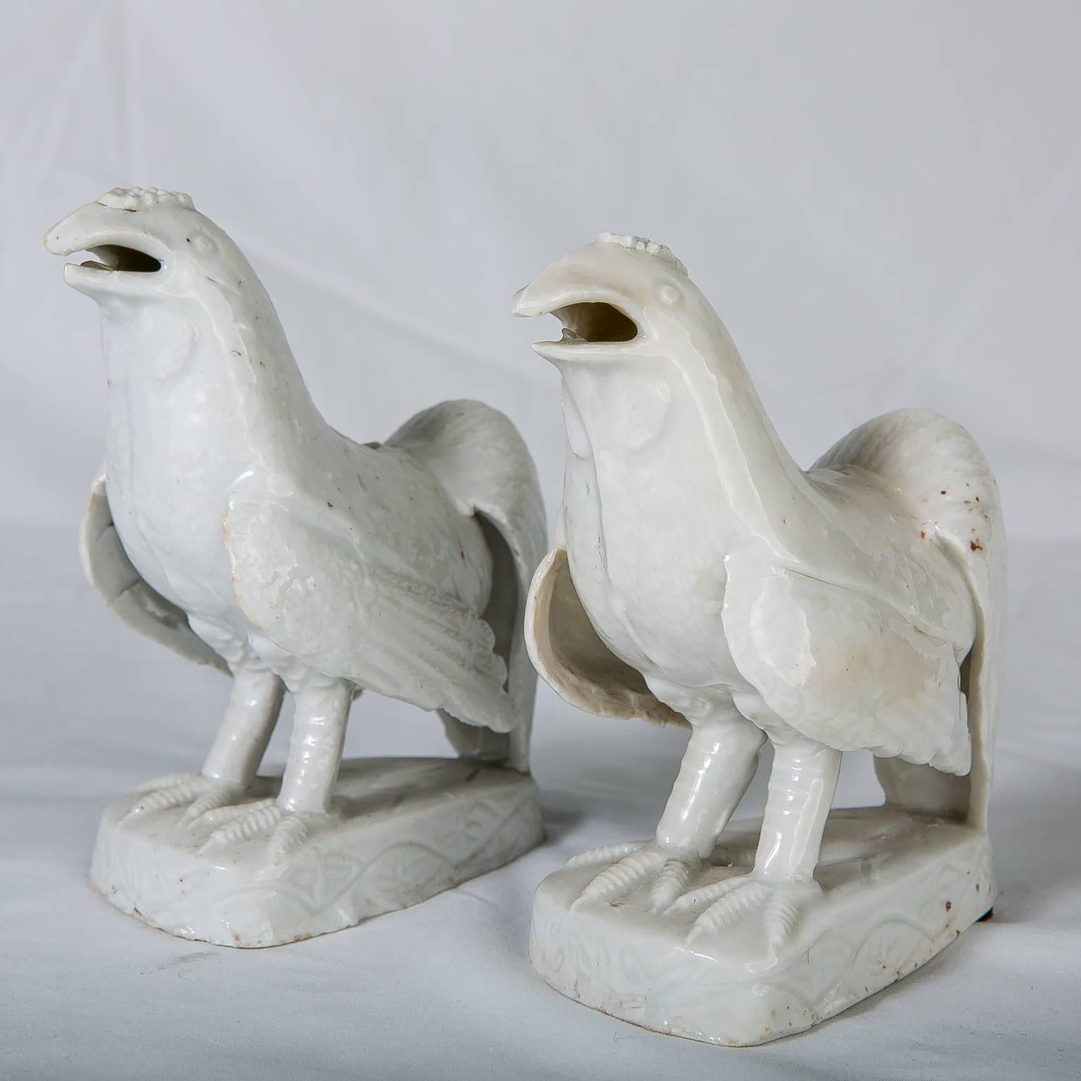 Pair of Blanc de Chine porcelain roosters with detailed feathers on the body and tail. They are modeled standing on a traditional shaped raised base. Like these roosters, Blanc de Chine figures are typically not decorated.
Blanc de Chine refers to