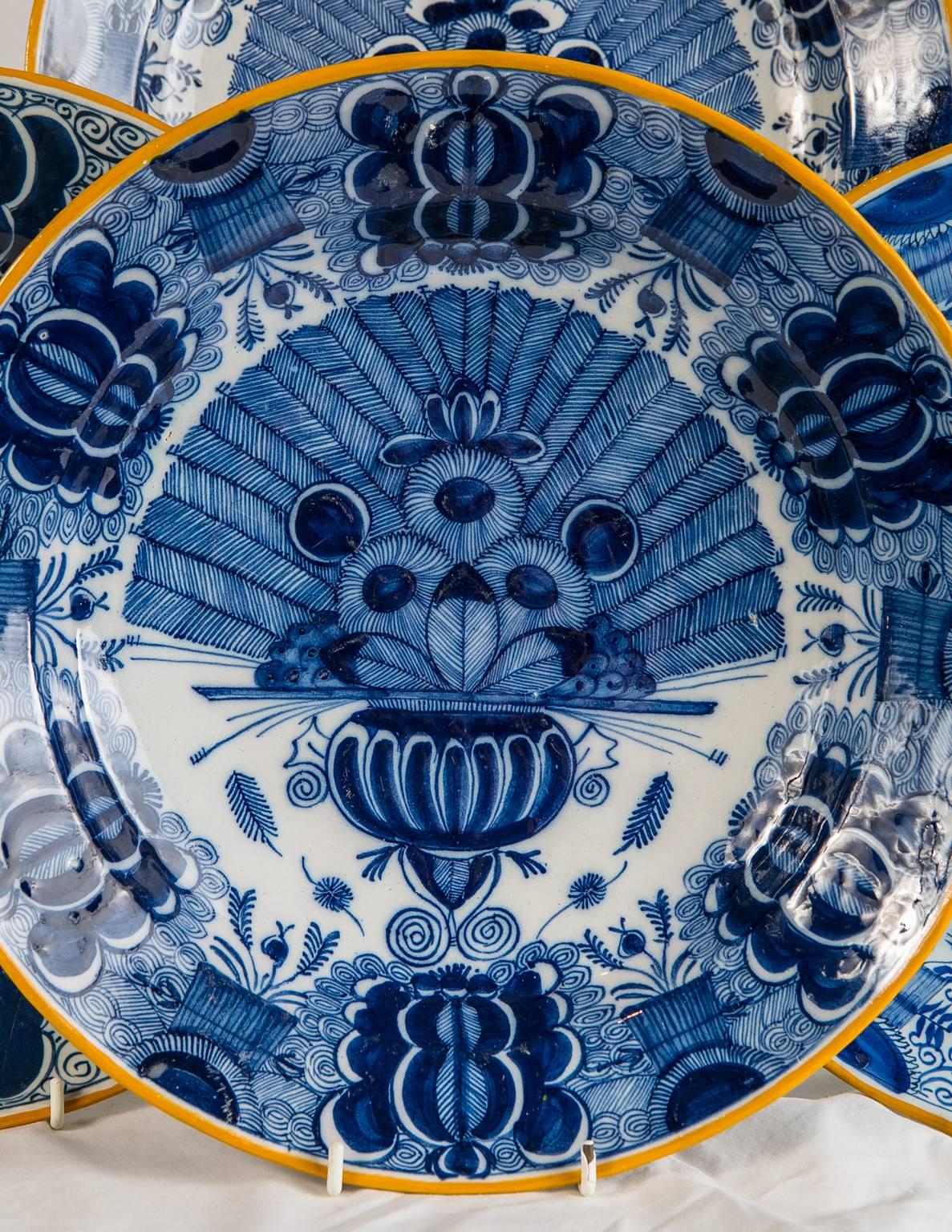 WHY WE LOVE IT: What a table setting!
We are pleased to offer a dozen large Dutch Delft Blue and White chargers hand-painted in deep cobalt blue. The rim of each charger is painted with yellow slip.
The exquisite hand-painted design shows a vase