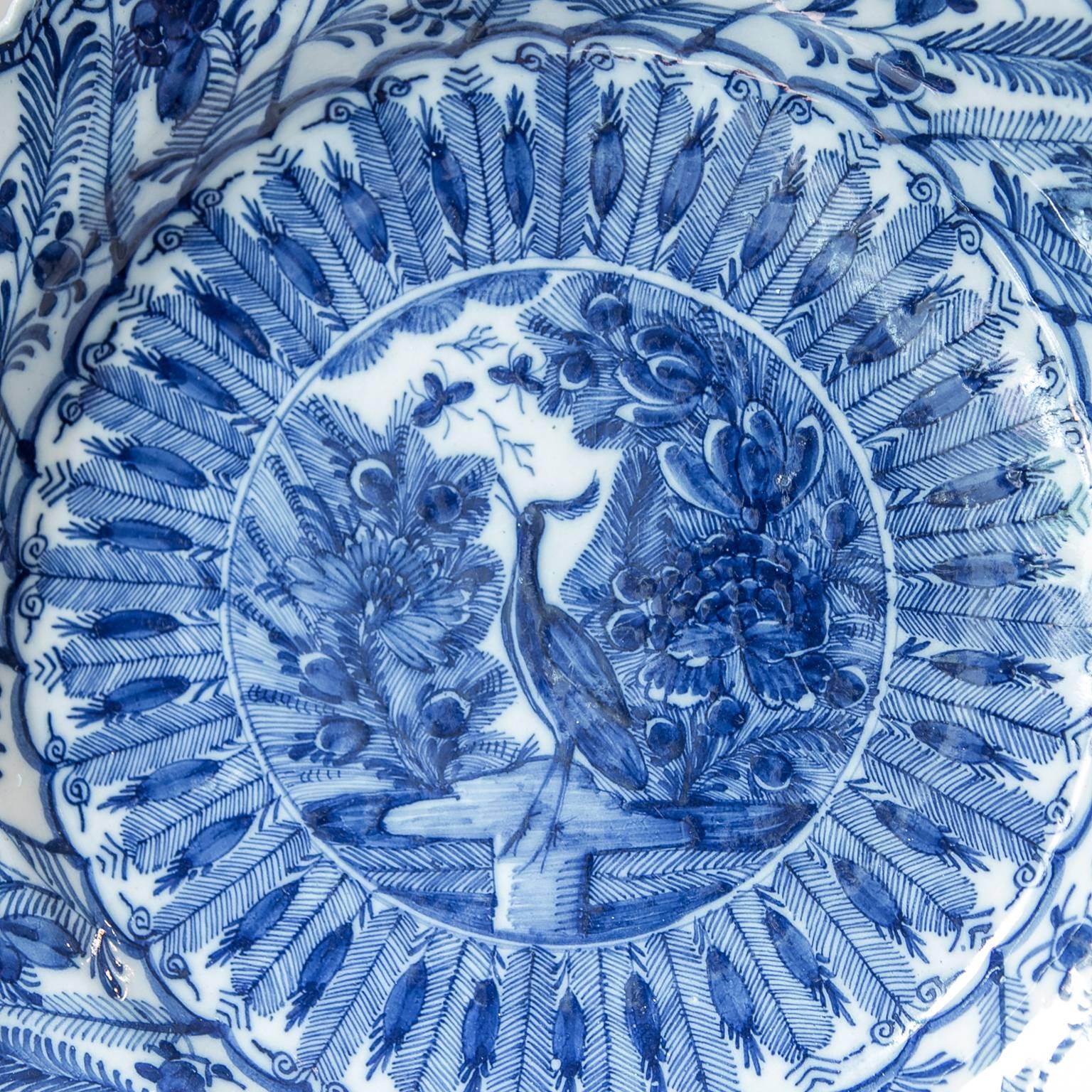 An outstanding pair of Dutch Delft Blue and White chargers made by The Claw factory. The entire surface of the charger is filled with designs inspired by Chinese porcelains from the Wanli period. The central scene shows a crane standing in water