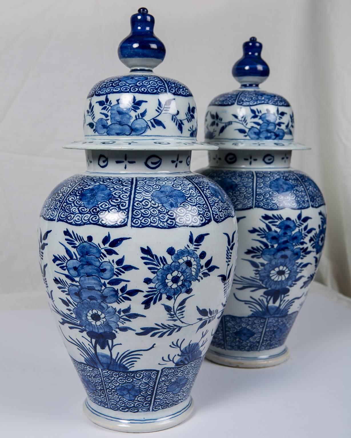 Pair of Dutch Delft blue and white antique ginger jars painted in a deep cobalt blue.
The jars are decorated all around with sprays of chrysanthemums. The tops, shoulders, and bases are painted with scrolling vines and flower heads.
Made in The