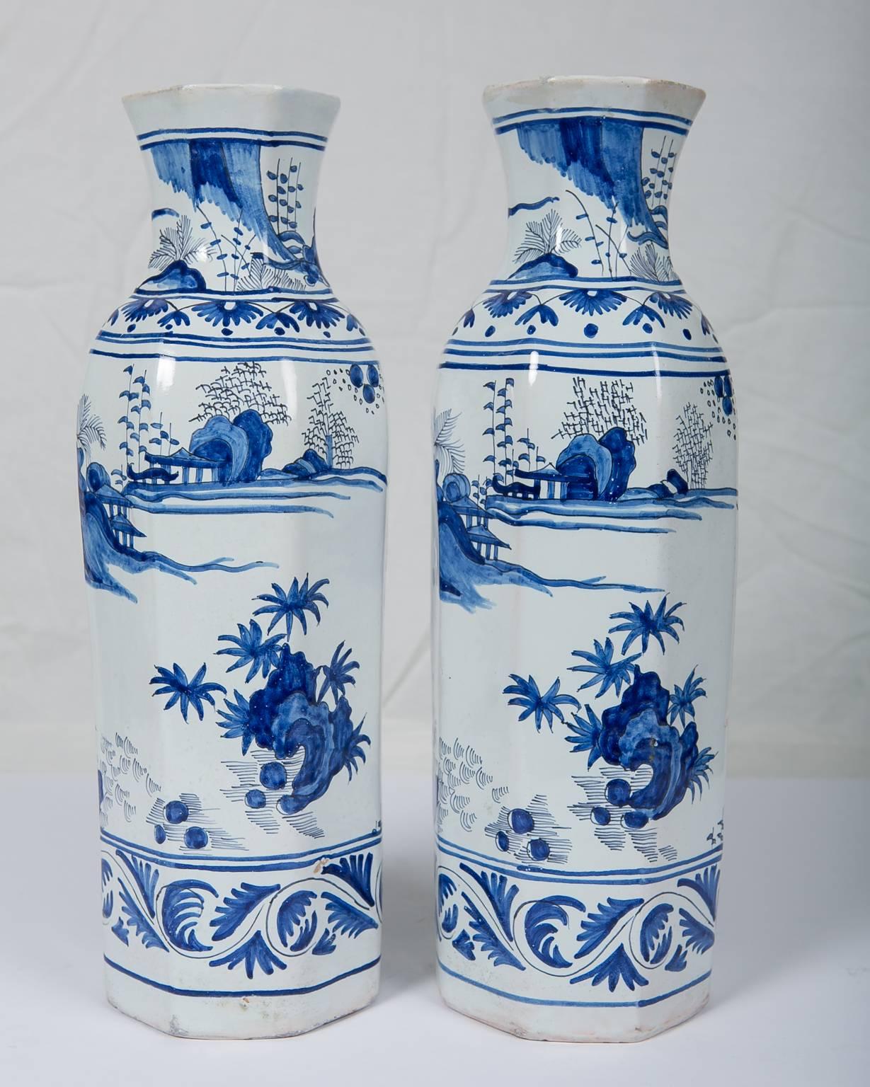  Blue and White Delft Vases Antique A pair of tall, octagonal, blue and white Dutch Delft vases painted in cobalt blue. We see a royal first grade bodyguard wearing Qing style headgear and traditional robes. In the background are pagodas and rocky