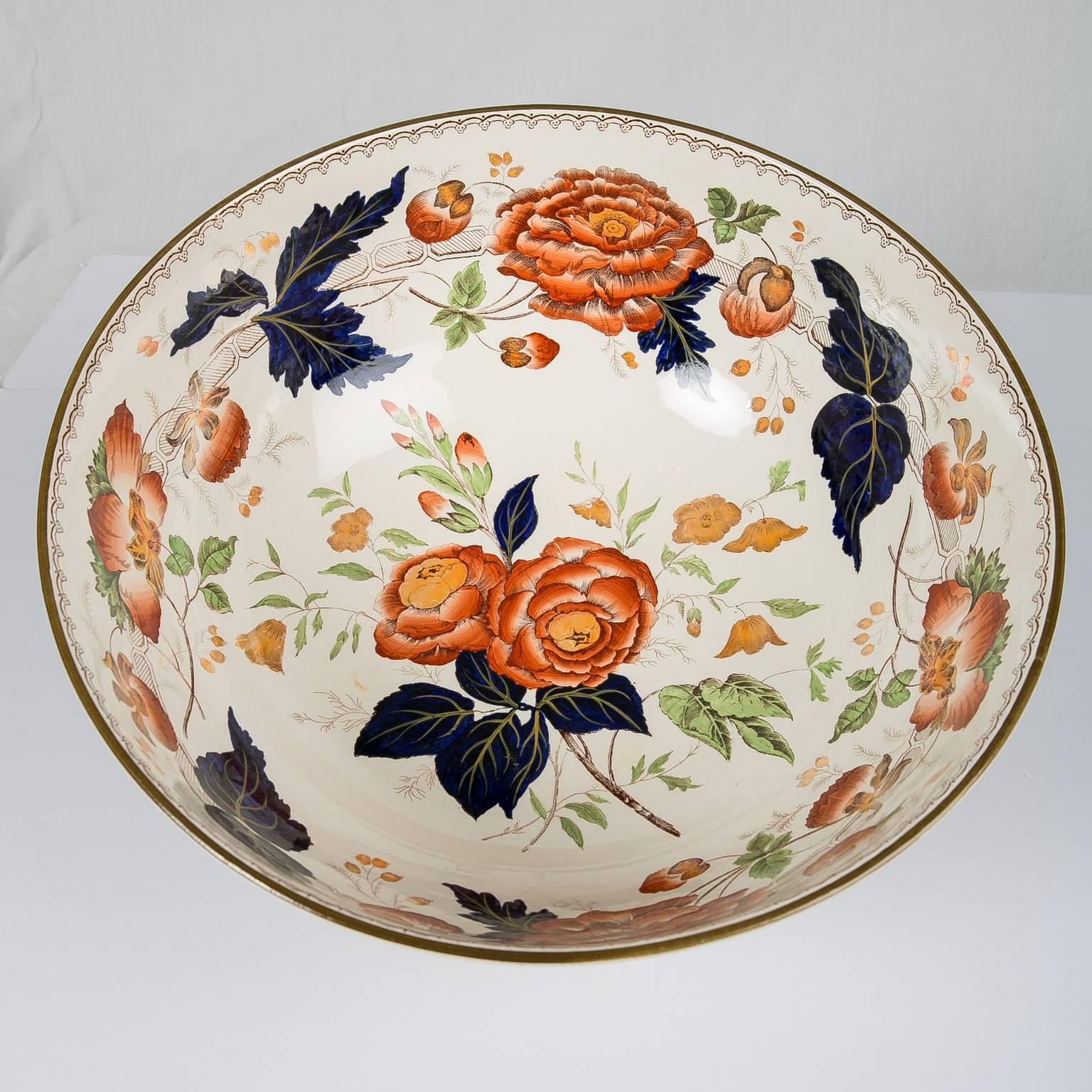 A large Wedgwood punch bowl decorated with orange peonies, and blue and green leaves in the style of the Aesthetic movement. Made in England, circa 1880 the bowl follows one of the core tenets of the Aesthetic movement. It shows that decorative