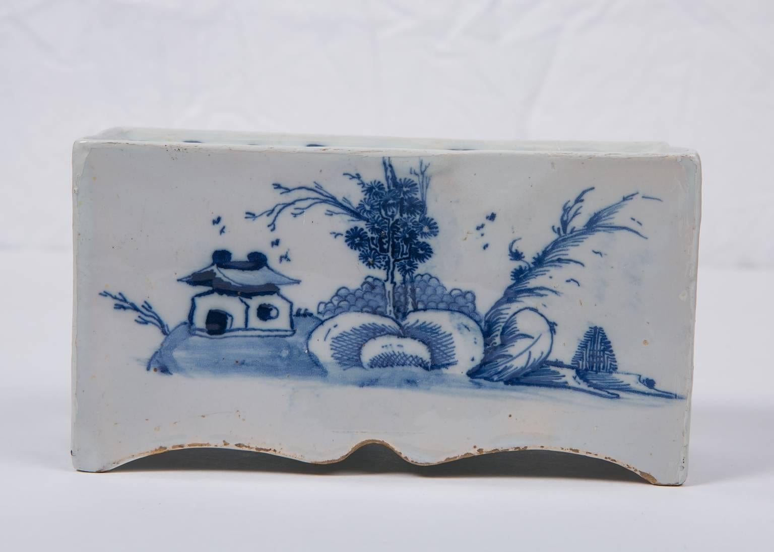 A Blue and White Delft Flower Brick made in Bristol, England circa 1750.  Flower bricks were most likely made to hold dried flowers as it seems it would have been too difficult to clean the inside of any flower debris. 
Each long side of the brick