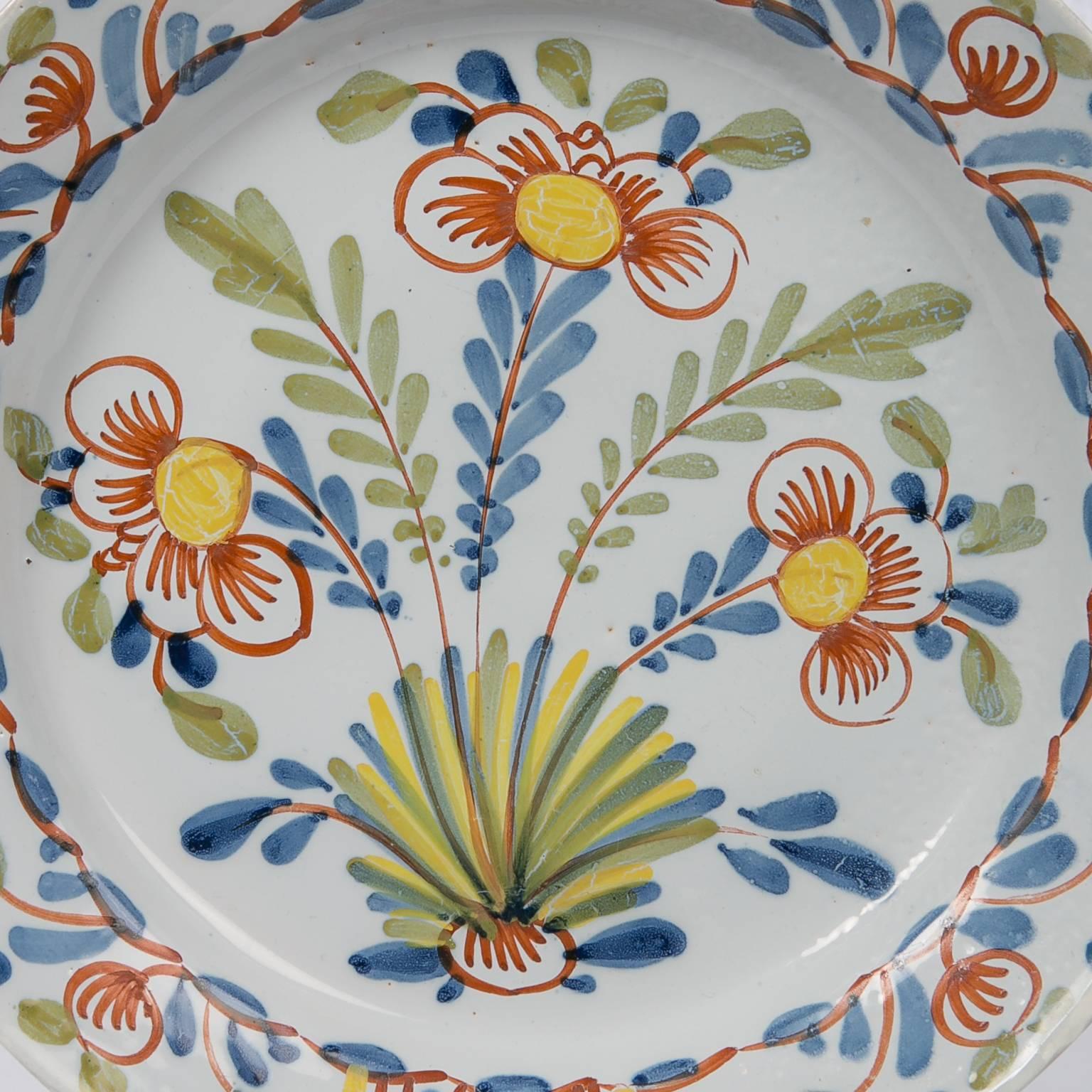 WHY WE LOVE IT: Just dreamy
 This exceptional English Delft charger was hand-painted in the early 18th century. Decorated with tulips painted in soft colors of green, orange, blue, and yellow it is one of the finest polychrome Delft chargers the