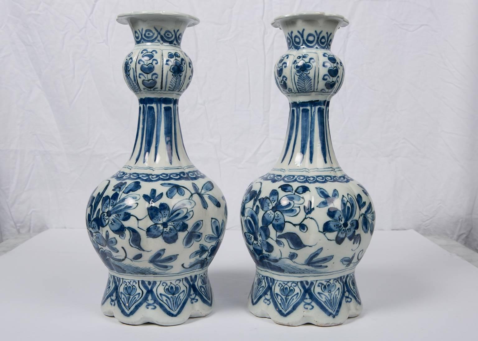 Pair Blue and White Dutch Delft vases painted in deep cobalt blue, each vase is beautifully decorated with a continuous scene showing showing peacocks in a flower filled garden. The necks are painted with exotic banana leaves. The lobed octagonal