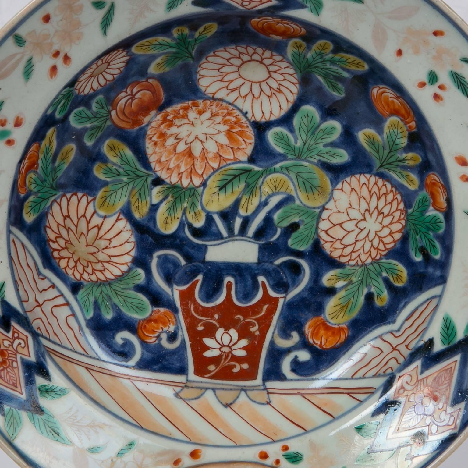 We are pleased to offer this Chinese Bowl, made during the reign of the Daoguang  Emperor, circa 1820, is painted in Polychrome Colors ( many colors)  decorated with buds and blossoms of chrysanthemums and peonies. The flowers are placed in a