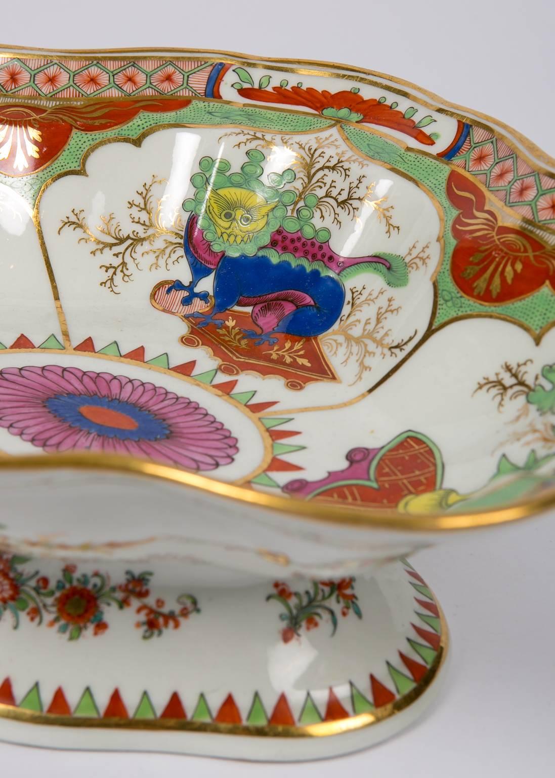 A Bengal tiger bowl with attached stand made by Chamberlains Worcester. The pattern is an exotic English interpretation of Chinese export porcelains from the Kangxi period. The design features four lappet-shaped panels which alternate between