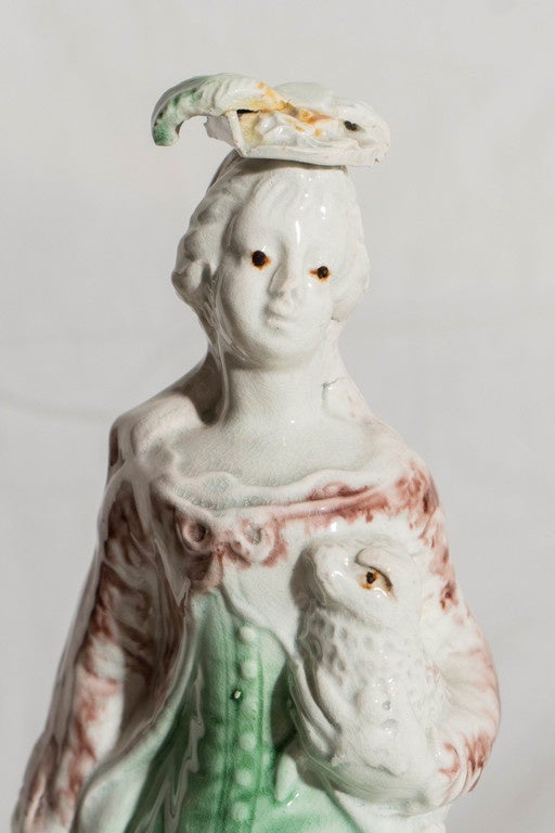 A charming 18th century Staffordshire creamware figure of a shepherdess holding a lamb. 
Modeled by Ralph Wood she is made of earthenware decorated with Whieldon type colors.
For an image of a similar figure see 