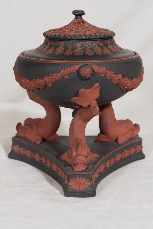 We are pleased to offer this incense burner in the Egyptian Revival style made by Wedgwood in a combination of Black Basalt and Rosso Antico stonewares. 
My favorite part of this piece is the beautiful cover with a pierced web of Rosso Antico (see