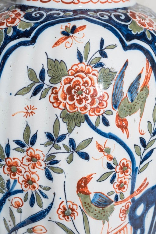 A pair of Dutch Delft polychrome vases painted in the traditional Kashmir palette of cobalt blue, green and orange. Decorated with panels showing scenes of long tailed birds in a flower filled garden. The border of each panel with scrolling vines on