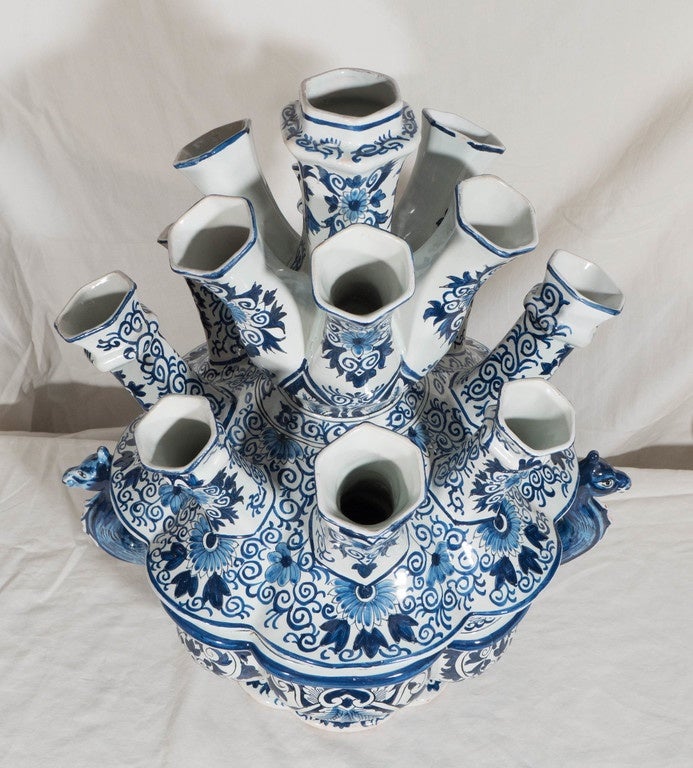 A Dutch Delft Blue and White *tulip holder with 15 spouts. The shape is circular with eight lobes and a pair of dragon form handles. This is a rare form which can work as a centerpiece on either an oval or round table. Decorated in cobalt blue with