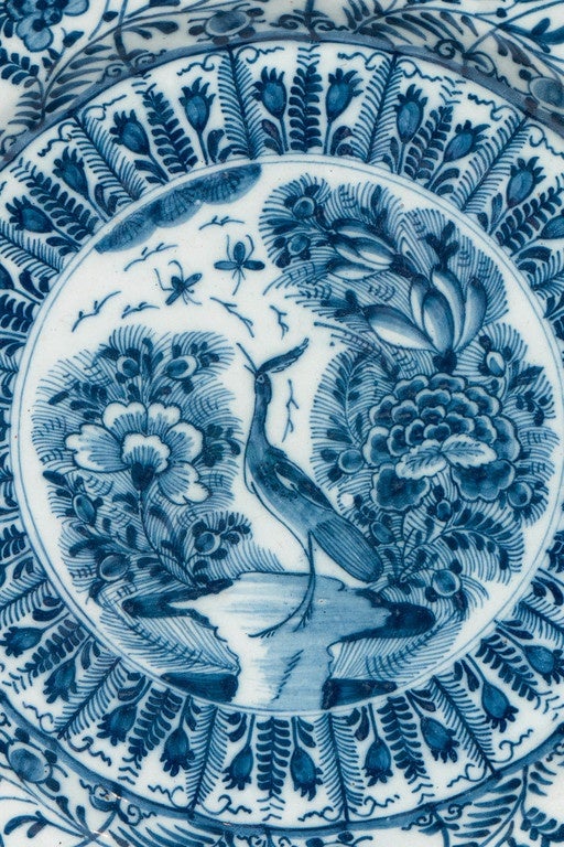 An outstanding pair of Dutch Delft Blue and White chargers made by  De Porceleyne Lampetkan, circa 1780. The entire surface of the charger is filled with designs inspired by Chinese porcelains from the Wanli Period. The central scene shows a crane