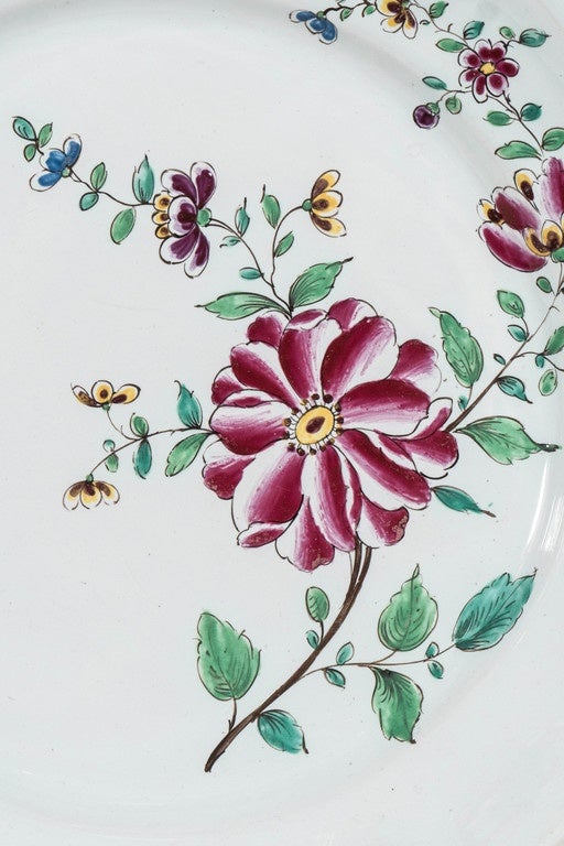 A pair of beautifully hand-painted 18th century French faience dishes with enamel decoration showing a single large purple peony together with sprigs of smaller flowers. This type of decoration was a popular design on late 18th century faience