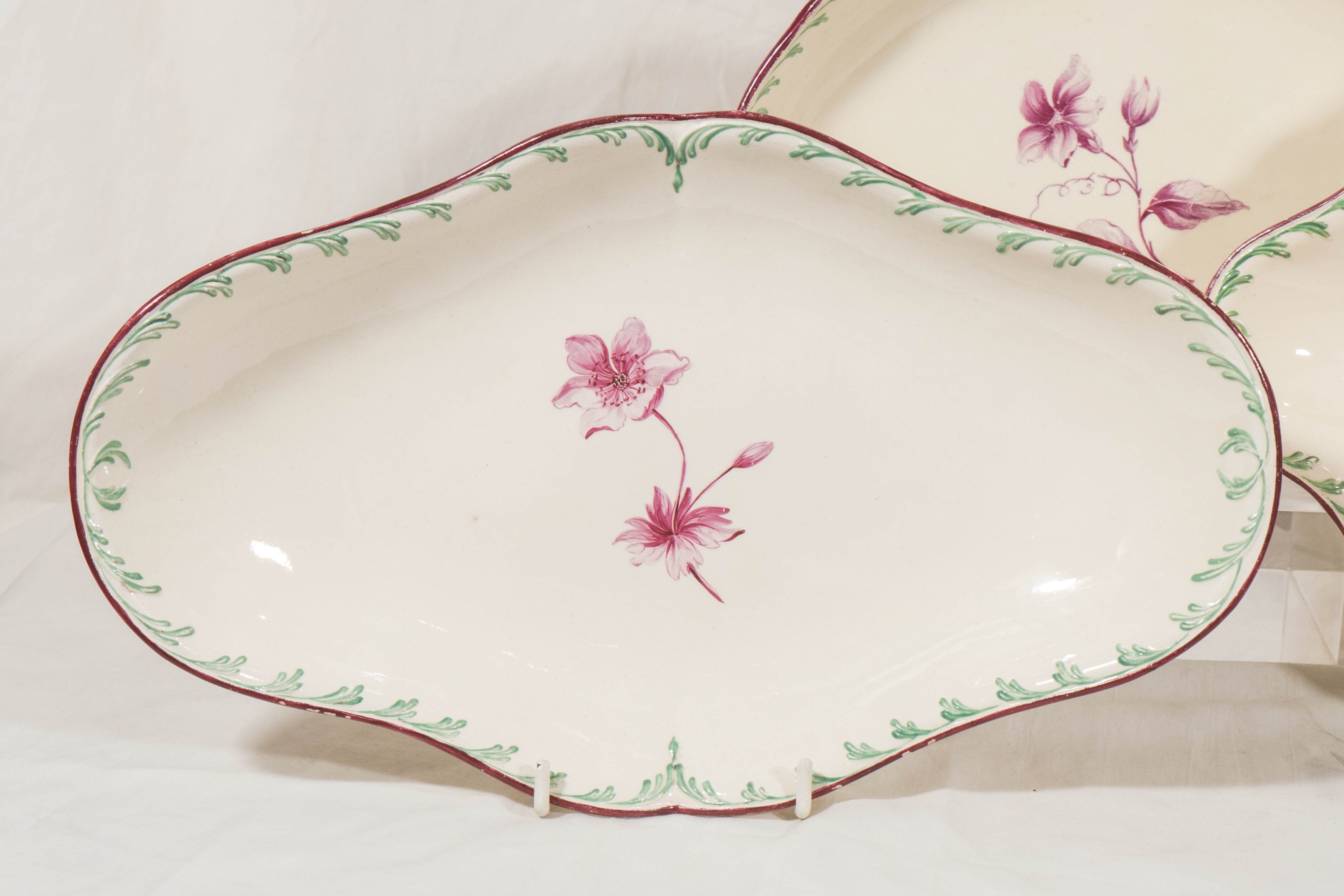 An outstanding group of 18th century Wedgwood creamware dishes each dish delicately decorated with a single purple flower in the center. The borders painted with green feather edge decoration and a purple painted edge.
Most likely these dishes were