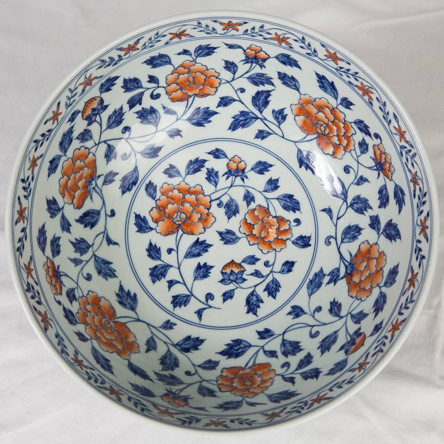 Antique Chinese porcelain bowl painted outside and inside with overglaze orange peony and morning glory on continuous leafy stems of underglaze cobalt blue. Around the foot is a band of blue cloud and thunder or meander decoration.
This bowl with