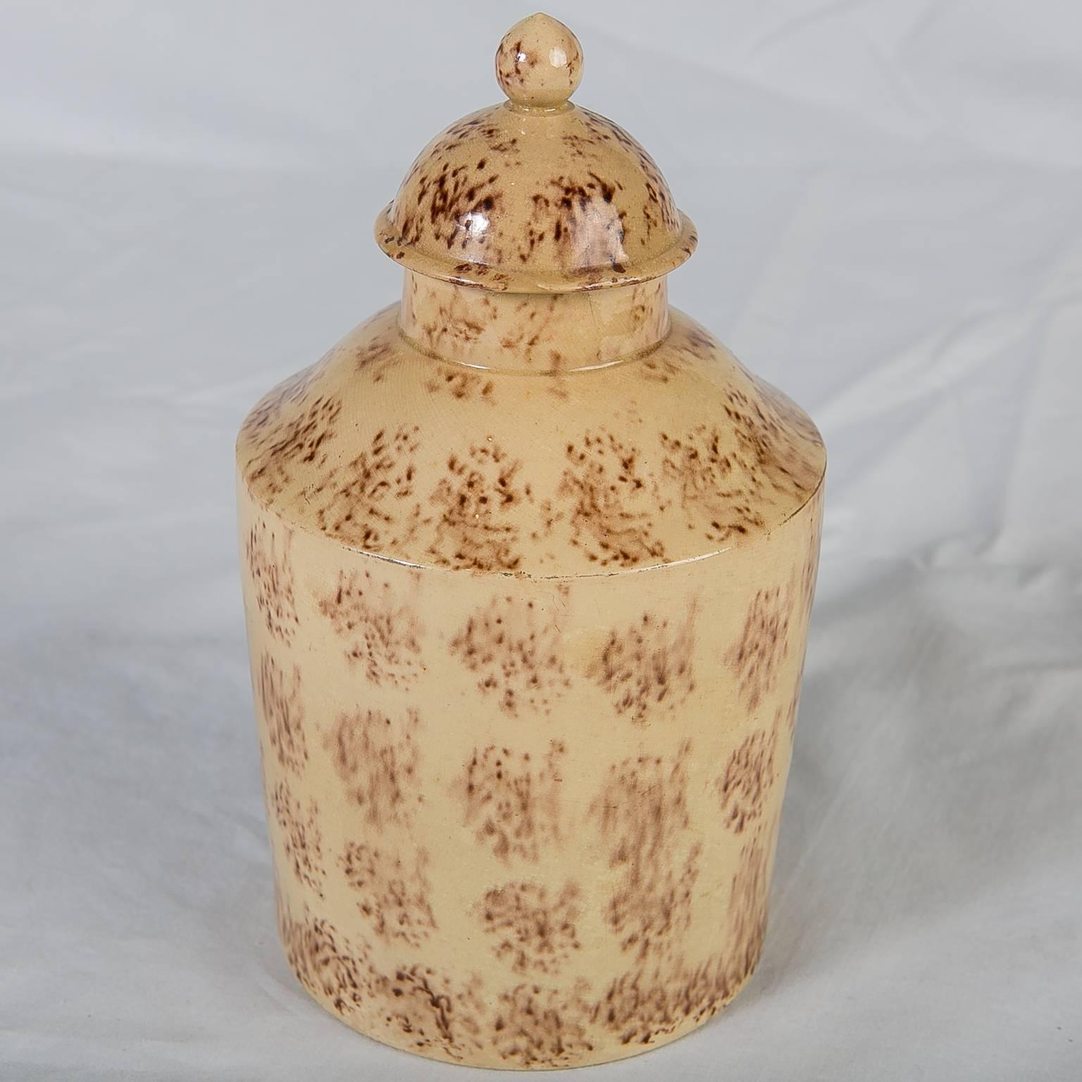 An 18th century English creamware tea caddy with sponged decoration. This early earthenware pottery was first painted beige and then decorated with sponged oxide glazes. It is a rare example from the period because most of the early decoration was