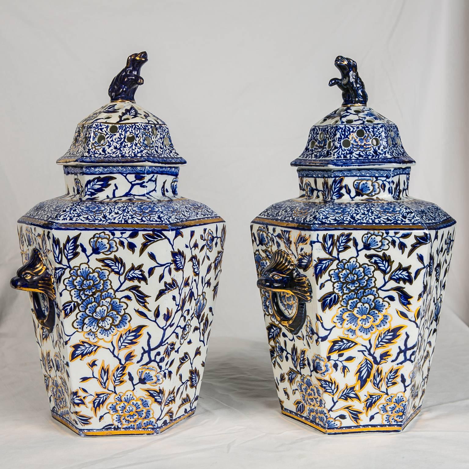 We are pleased to offer this pair of English blue and white hexagonal covered jars decorated with peonies and leaves with gilded outlines. The handles are formed as stylized foo lions decorated in cobalt blue with gilt highlights. Each vase has a