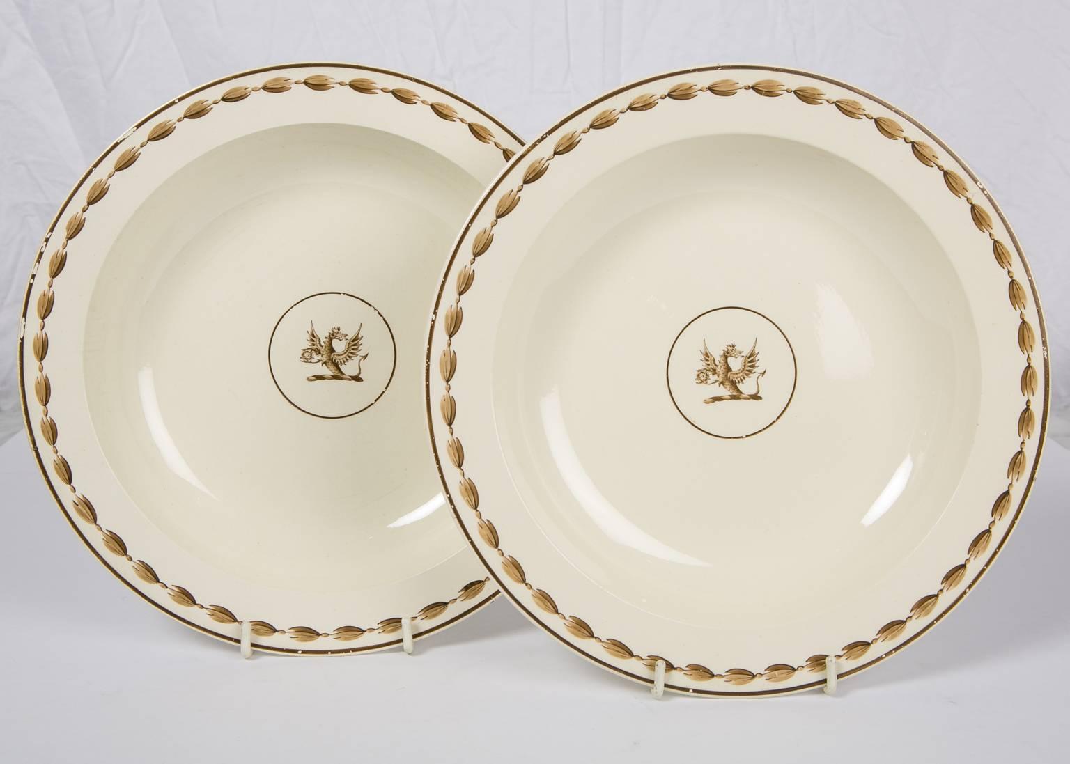 A pair of late 18th century Wedgwood deep dishes painted in shades of brown. The center of each dish has a crest showing a dragon with wings lifted holding a Tudor Rose. The Tudor Rose which Henry VII adopted at the time of his marriage conjoins the