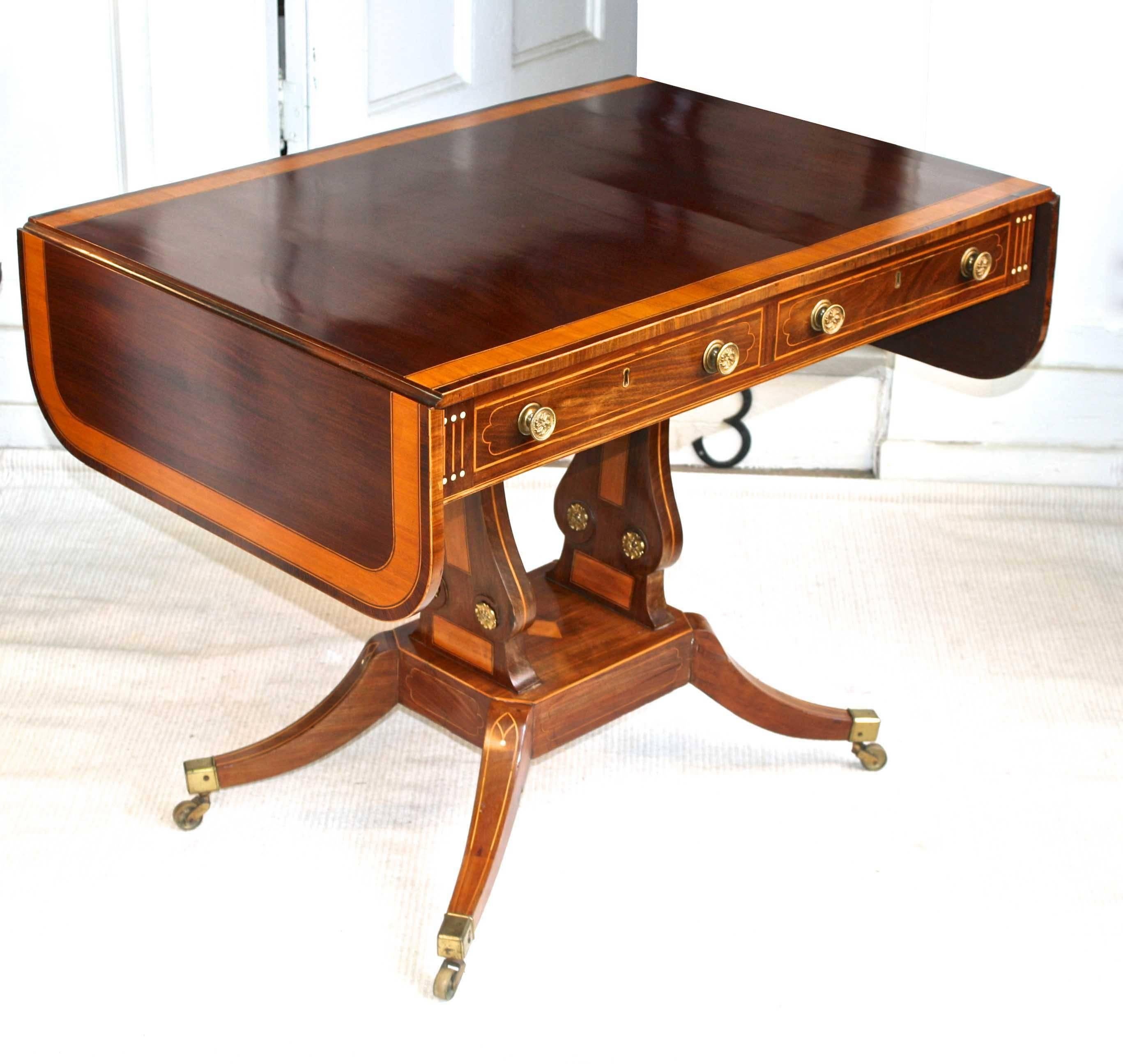 A satinwood and ebony inlaid, banded and veneered mahogany sabre-leg sofa-back or writing table just 25