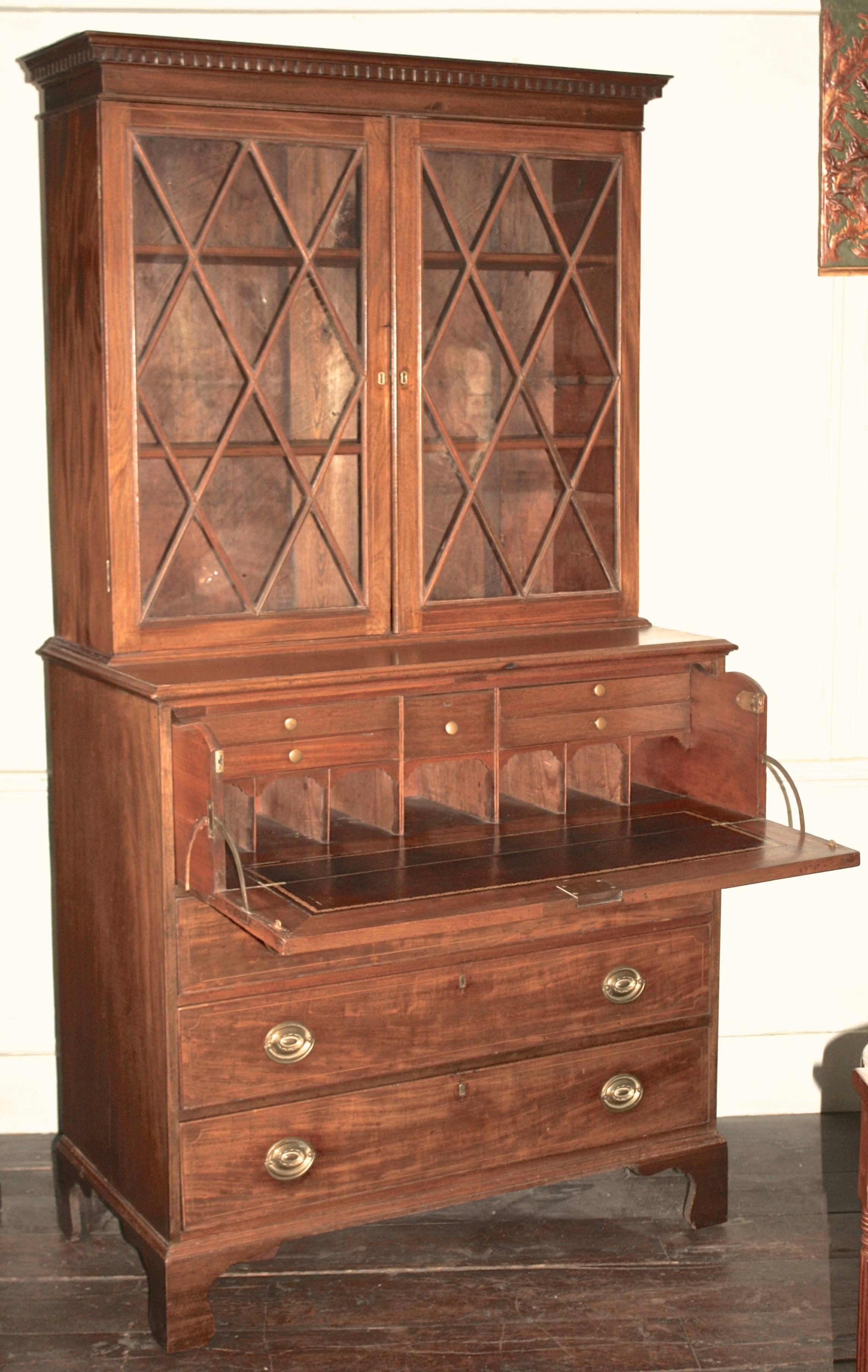 A Federal period pale mahogany Hepplewhite manner secretary bookcase with very fine rope and string inlays. Finish, glass, brasses and locks all original. In two parts: Three shelf bookcase with diamond mullioned doors, atop a lower case containing