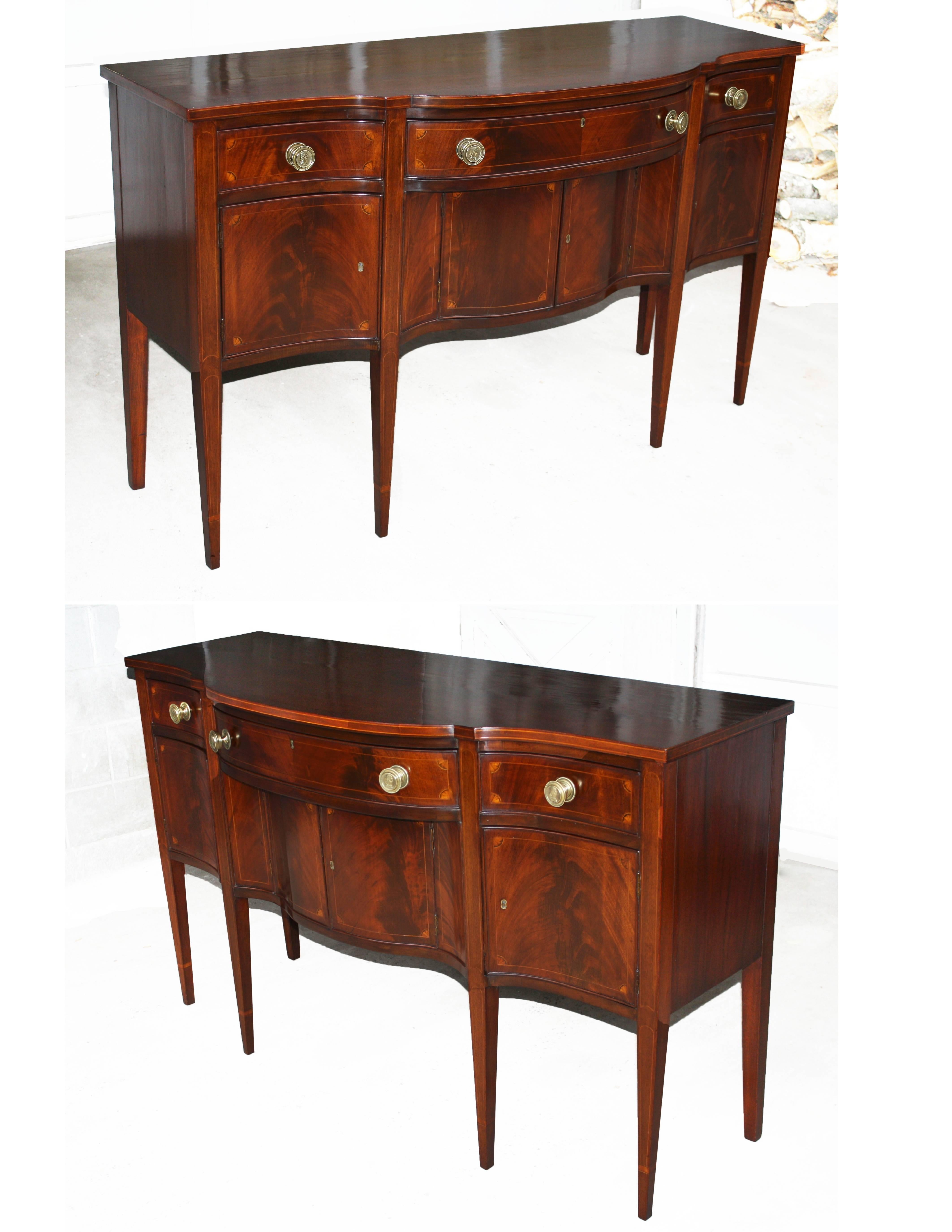 In the Hepplewhite manner, an American Federal period satinwood fan and string inlaid mahogany sideboard of Southern origin.  Drawer and door fronts are crotch mahogany veneered.  The four brass drawer pulls are 'after' the Houdon Bust of George