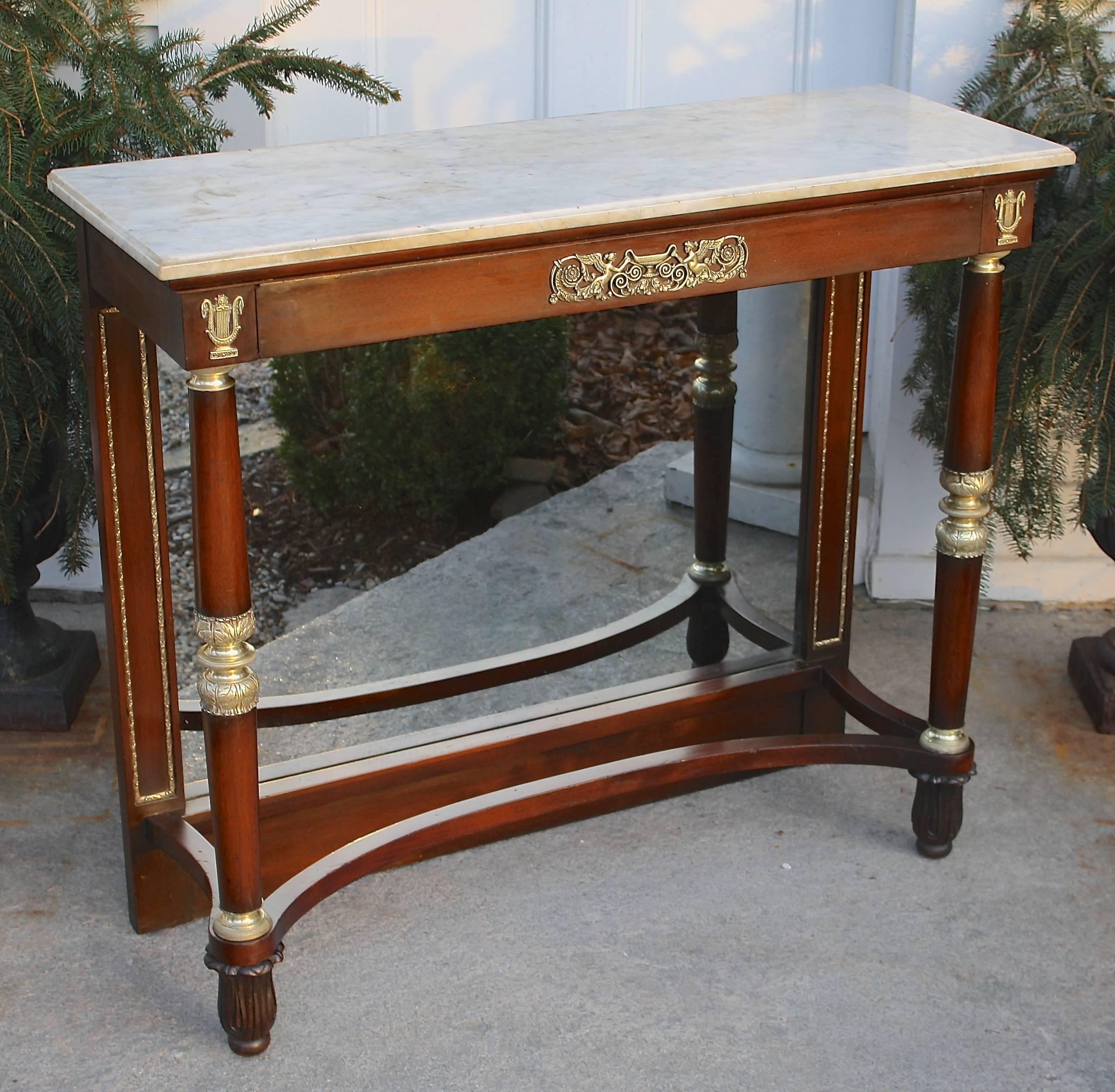 A French Restauration period marble-top mahogany pier table with exceptionally fine ormolu mounts of harpies and lyres to its apron. Three turned ormolu elements on the frontal columns; including three-tiered complex foliate turnings midway on each.