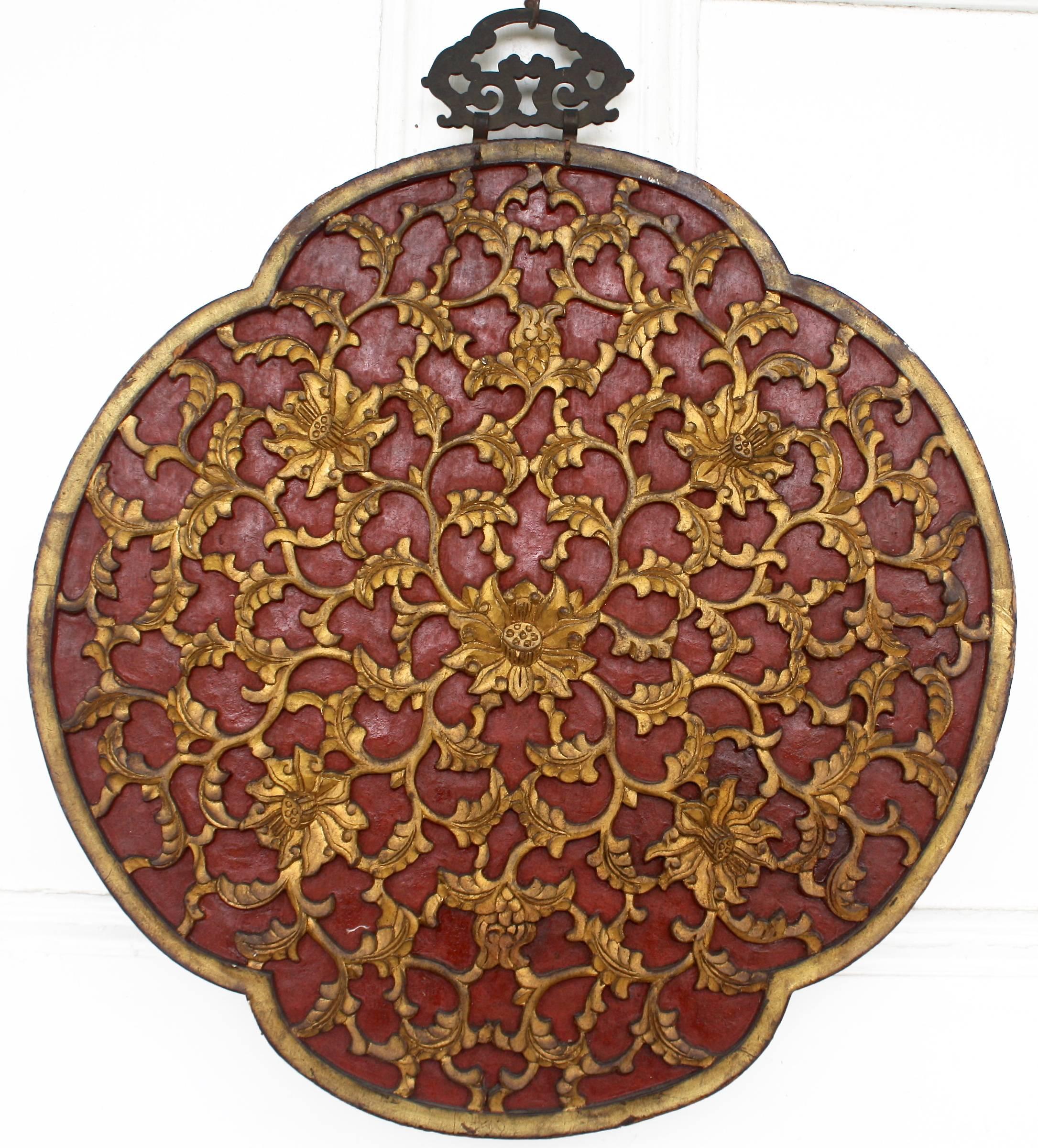 Dating from the reign of the Jiaqing Emperor (1796-1820), a two sided quatrefoil panel featuring a pheasant in foliage on ebony background on its primary side; with parcel-gilt foliate vine carvings on red background, en verso. Original hand-forged