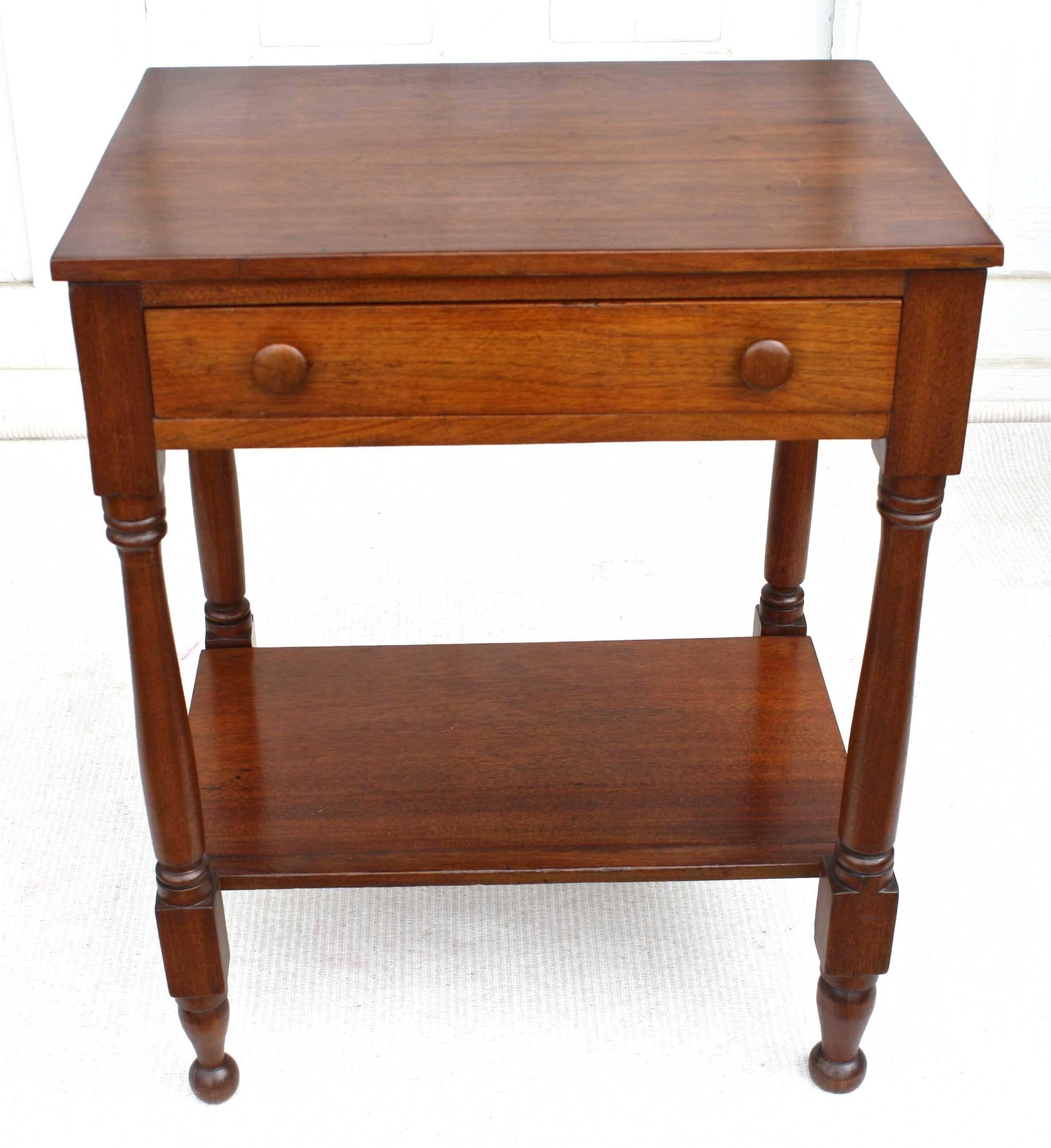 A single-drawered bedside table in the 'country' American Sheraton manner, with a stretcher-level chamber pot shelf. Its four legs are ring turned and 'blocked'. Pine secondary woods. This table may also serve chairside or at sofa-end, freestanding