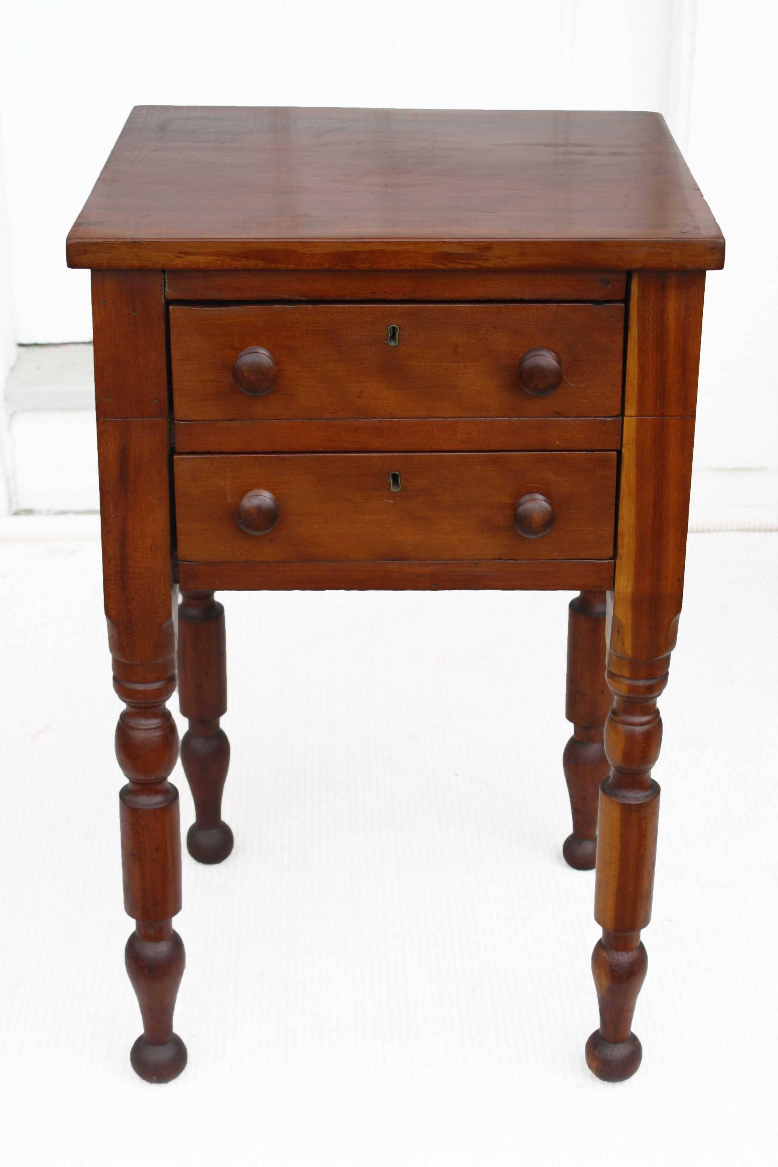 For bedside or chairside, a two drawer 'country Sheraton' table with complex baluster turned legs. Frequently labelled a 