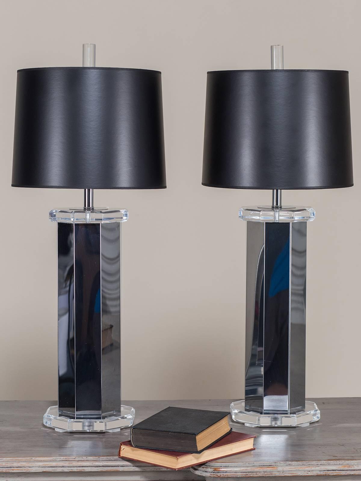 This pair of vintage Italian lamps circa 1975 combine two modern materials, chrome and Lucite, to give a striking contemporary appearance. Each lamp stands upon an eight sided octagonal base and supports a column of chromed metal also with eight