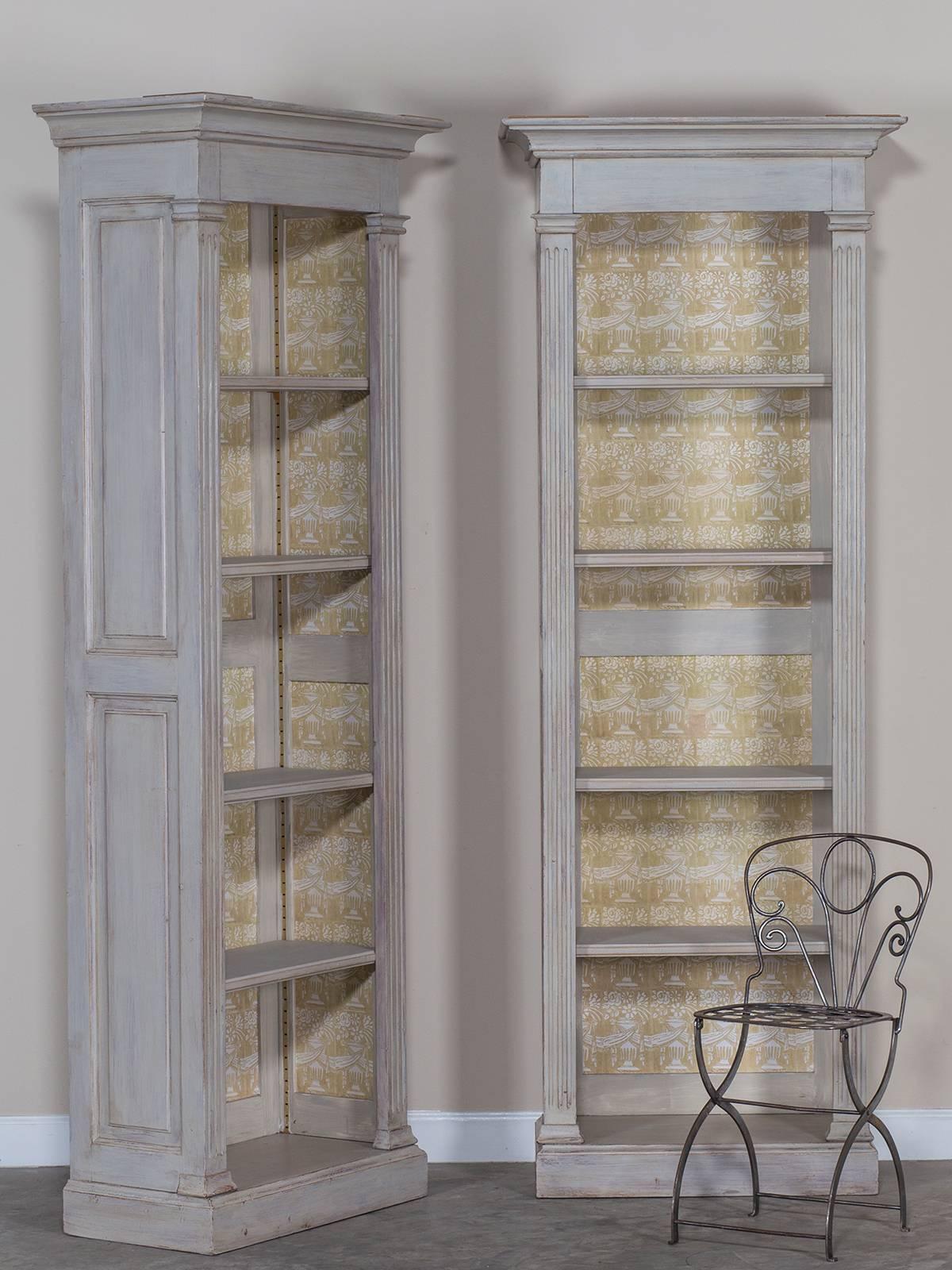 This elegant pair of vintage painted French neoclassical display cabinets bibliothéques are Louis XVI in style and showcase the marvelous simplicity of late eighteenth century design. Each painted French display cabinet or bookcase (or as the