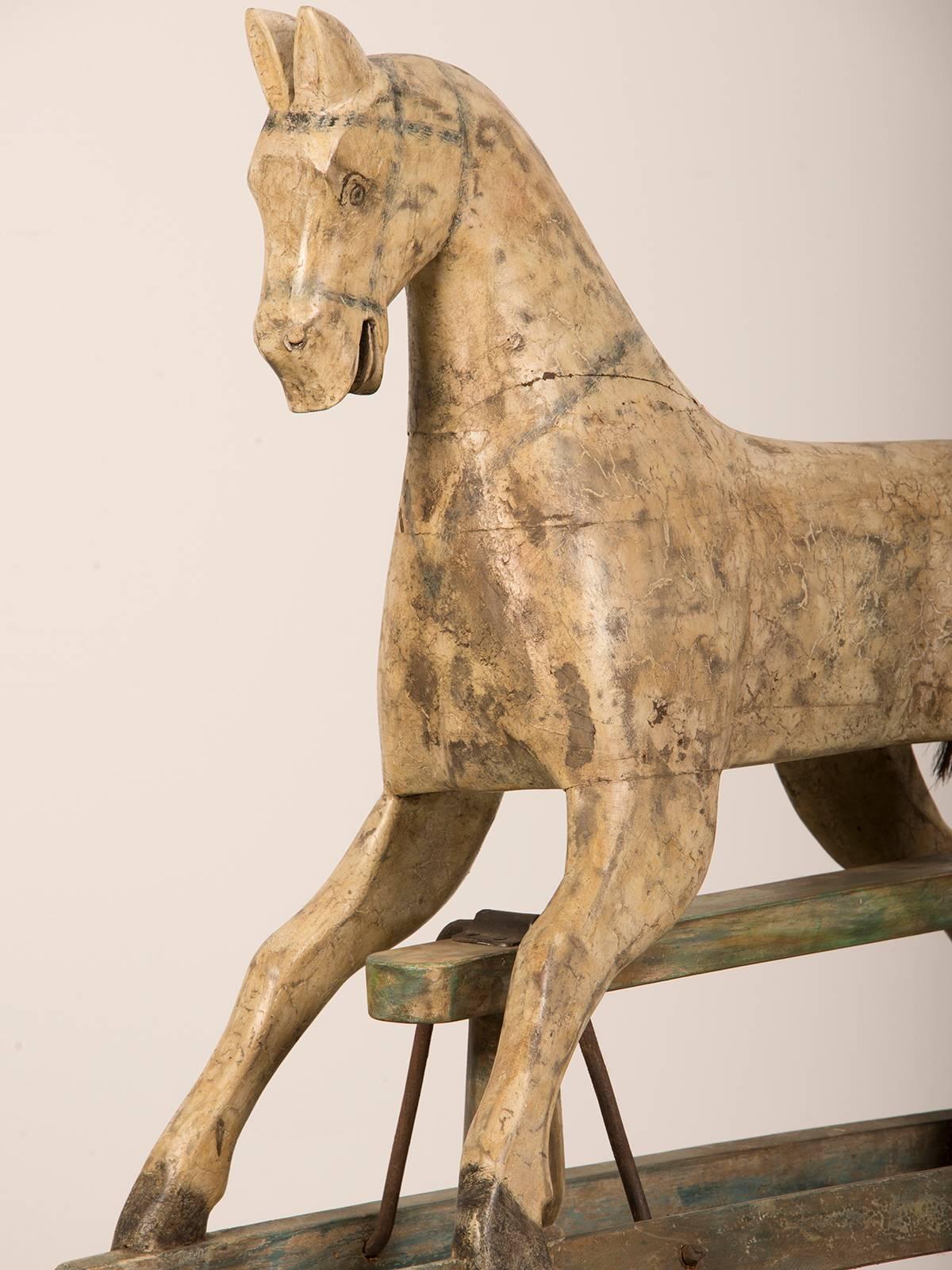 A painted wooden child's hobby horse with a dappled coat standing on a rocking stand found in France. The life like details and the original iron fittings that enable the horse to swing freely are wonderful aspects of this piece. The horse is