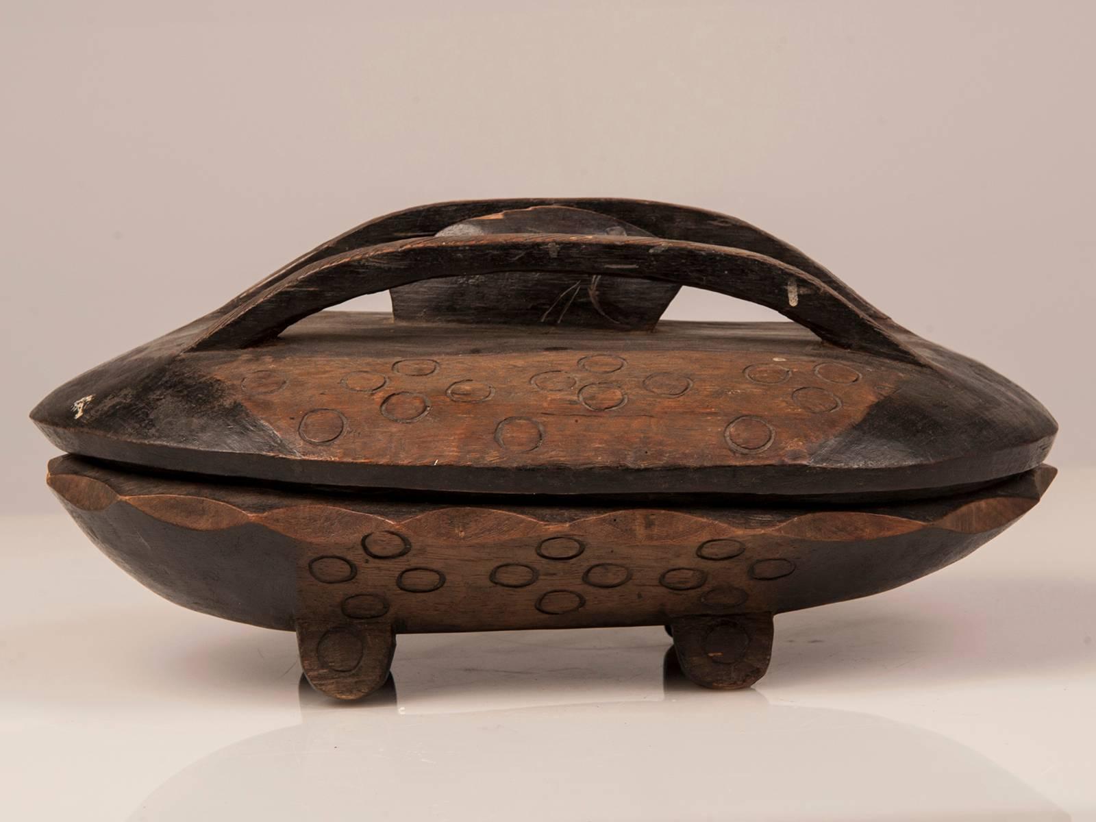 An antique African oval Zambian food bowl hand-carved and decorated from native timber with a interior divided food compartment and the original top from Africa circa 1900. Featuring native motifs and signs of use through the years this is an