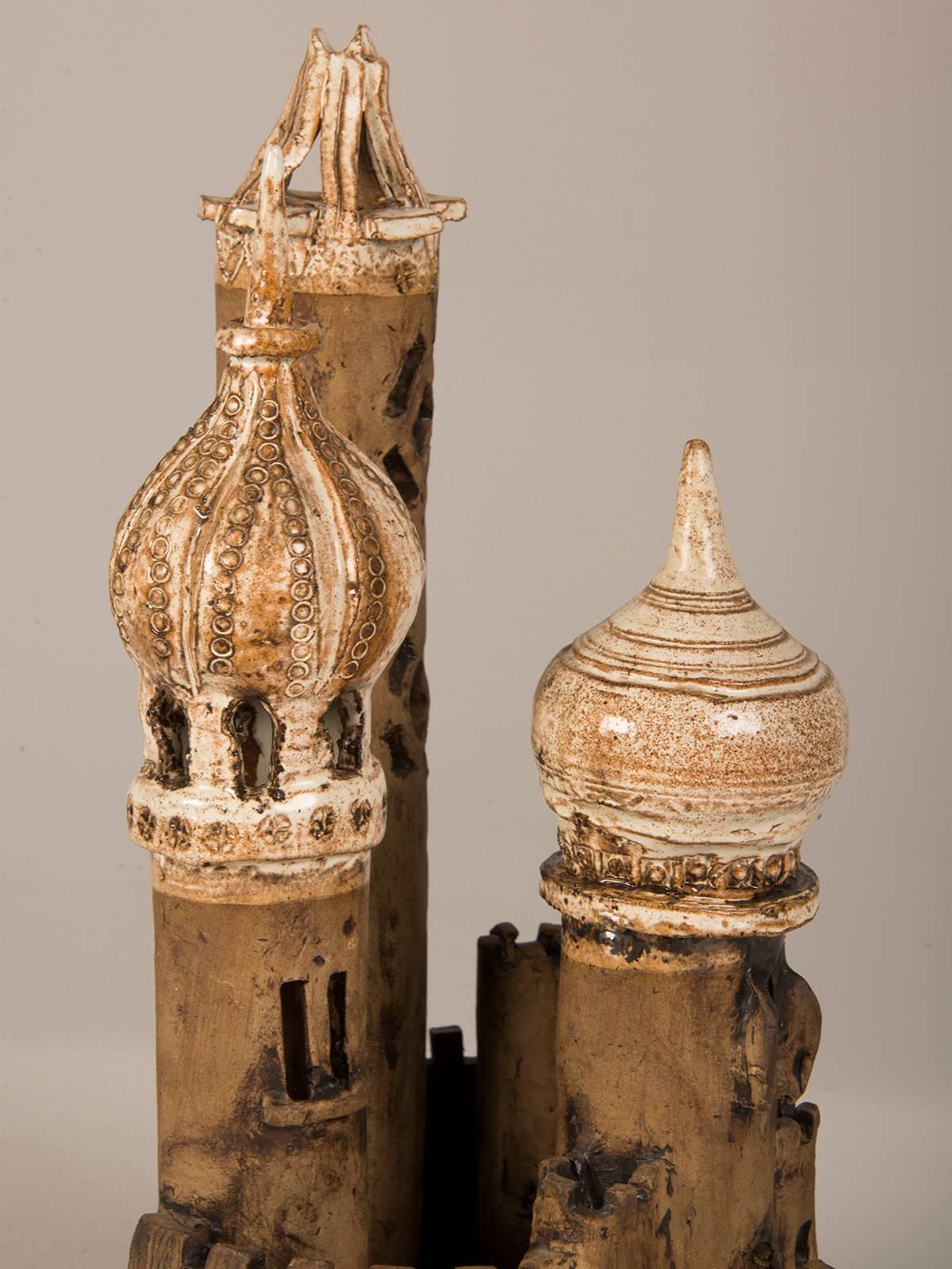 A vintage Polish fantasy castle circa 1950 made by hand of earthenware with three spires set within a wall. The fairy tale appearance of this castle relates to those seen in France that inspired the Disney castle for Sleeping Beauty.