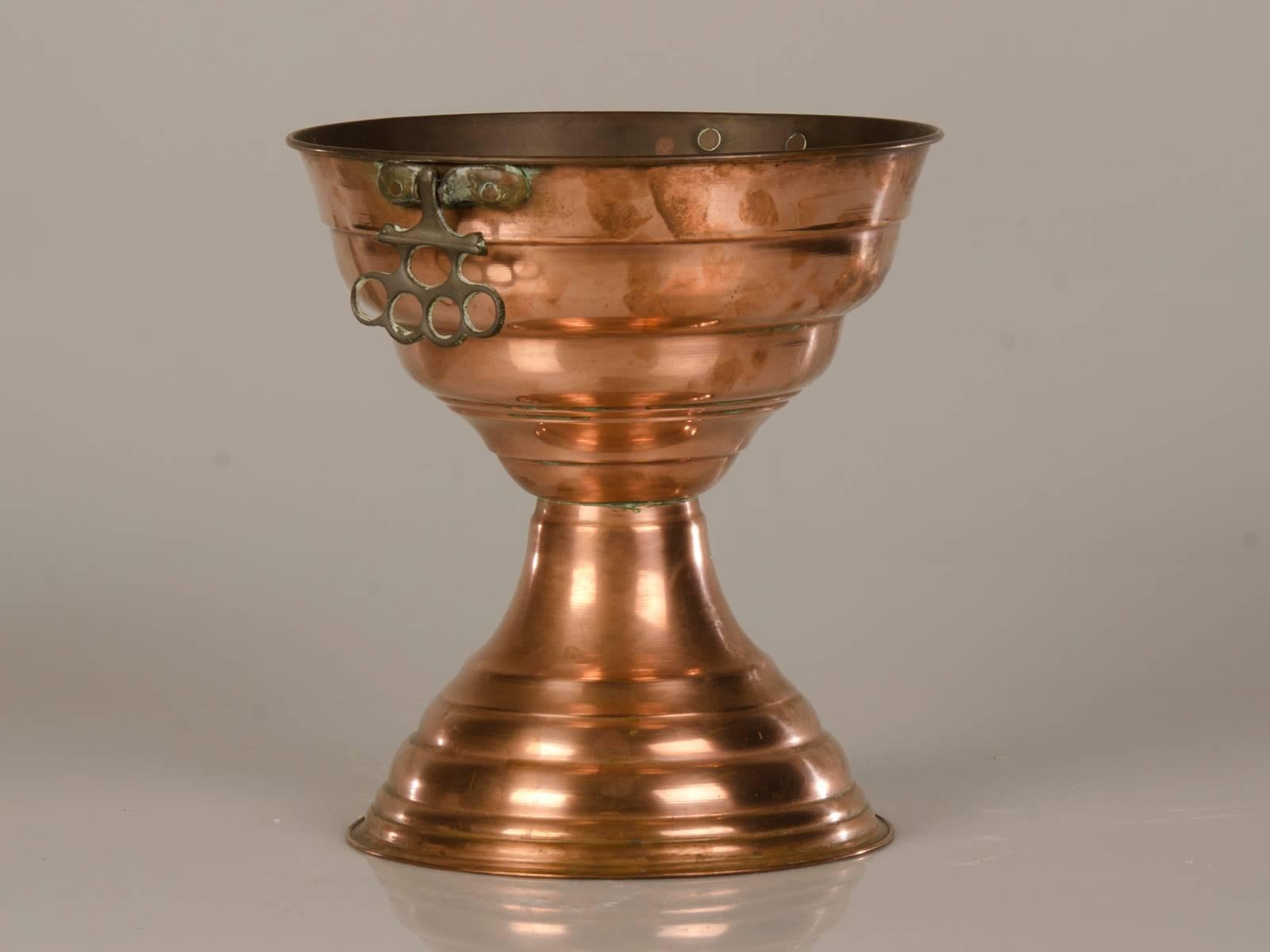 An unusual and tall antique French copper vase with a double bowl shape, circa 1910. The curious repetition of the shaped bowl gives this French copper vessel its decided allure. Both the upper and lower rims feature a rolled edge that perfectly