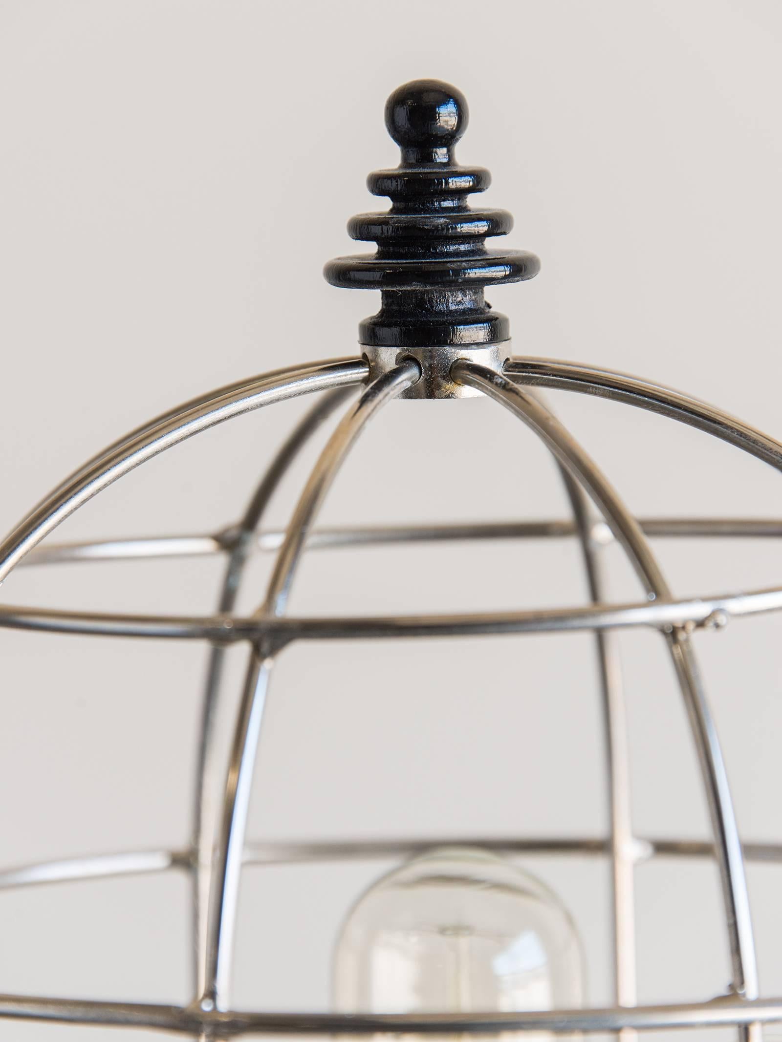 Be the first to see our new arrivals directly through 1stdibs! Please click follow dealer below. 

This modern lamp has a striking appearance due to the silver open cage shaped like a beehive and the jet black circular base. The base has a ridged