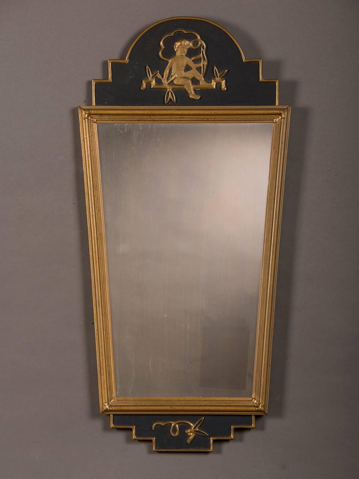 A neoclassical Swedish Gustavian Style painted frame enclosing the original mirror glass, circa 1890. The combination of the painted finish is offset with lovely gold leaf that highlights the charming putto seated at the top of the frame. The