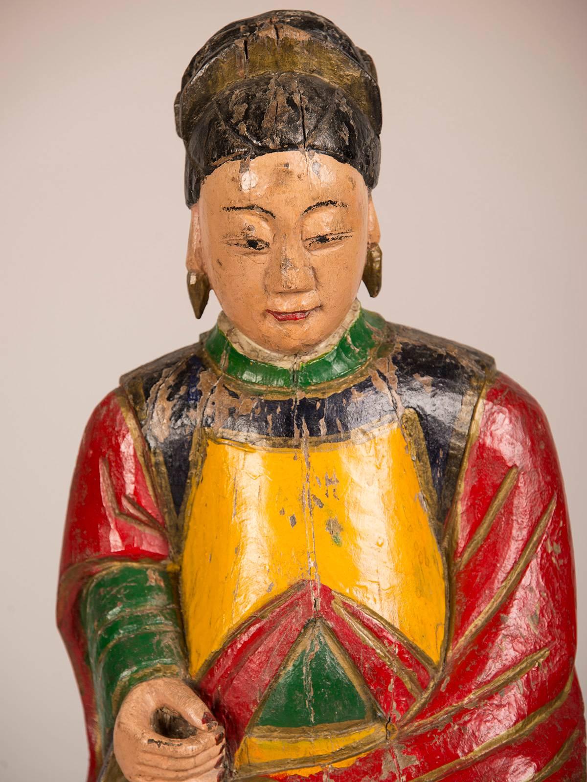A large hand-carved and painted female temple figure from the T'ung Chi period in China circa 1865. The beauty and serenity of this figure is evident in her seated position and calm facial expression. Most likely in her right hand there was a token