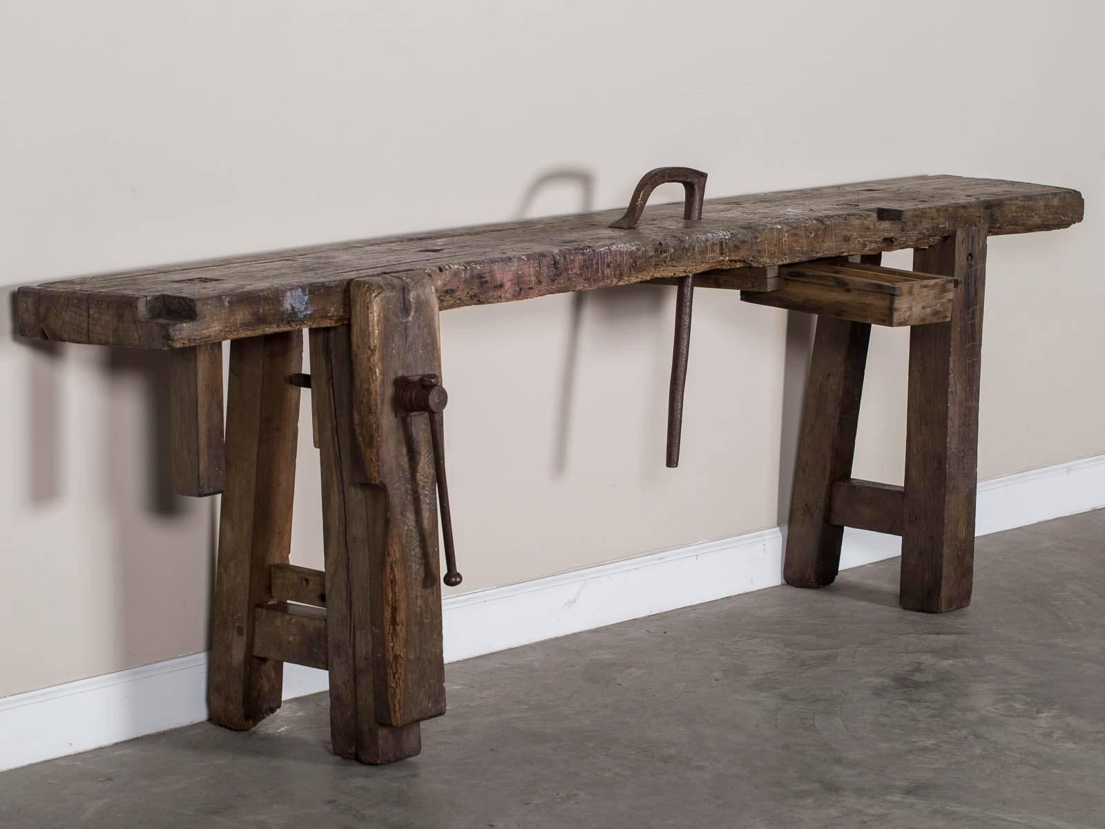 A wonderfully rough antique vintage French industrial solid oak workbench, circa 1900 with the original iron vise and removable iron guide. The sheer massive quality of the solid oak timber on this table is quite impressive. Originally designed and