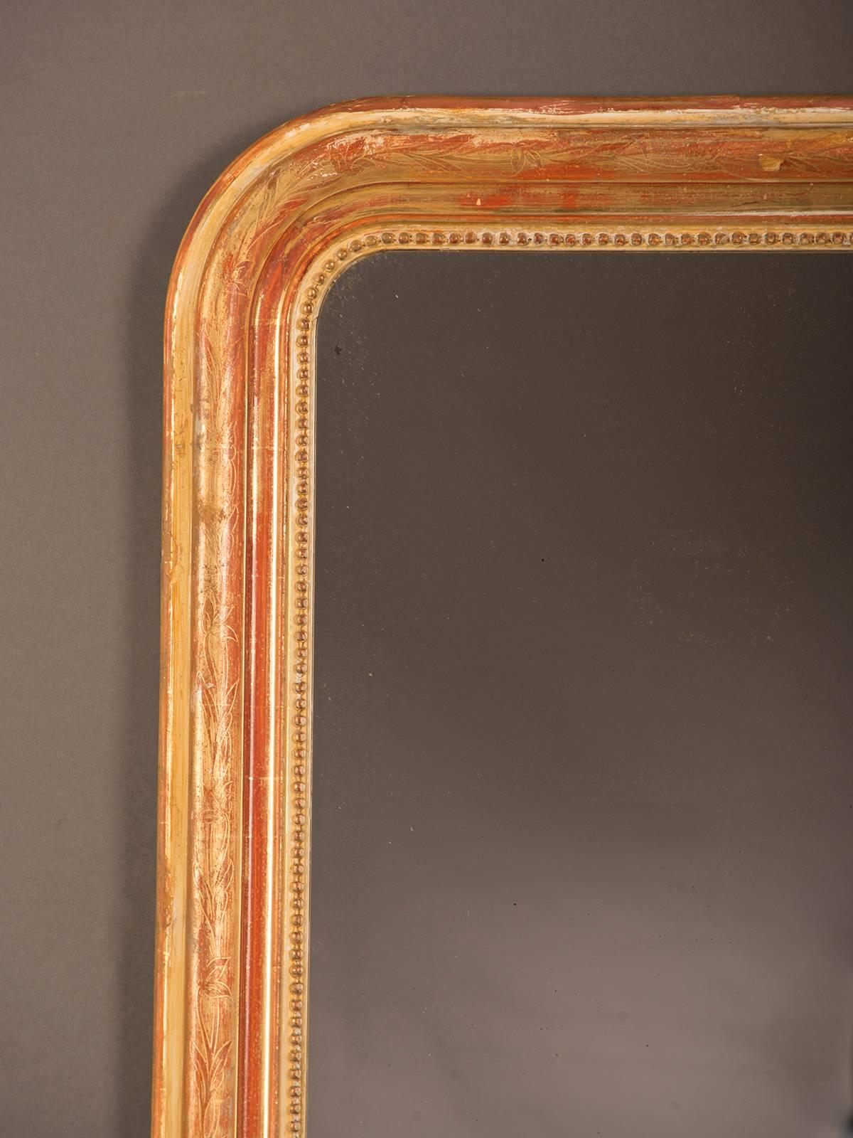A gorgeous Louis Philippe style antique French gold leaf frame surrounding the original mirror glass circa 1880. Please note both the beautiful proportion of width to height as well as the exceptional beauty of the original gold leaf that has worn