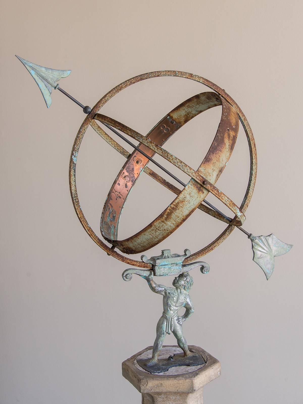 This charming French garden ornament features a tapered stone column with each of the six sides embellished with a climbing vine with well modeled leaves. The hexagon column supports a figure of a man holding aloft a large copper armillary sphere