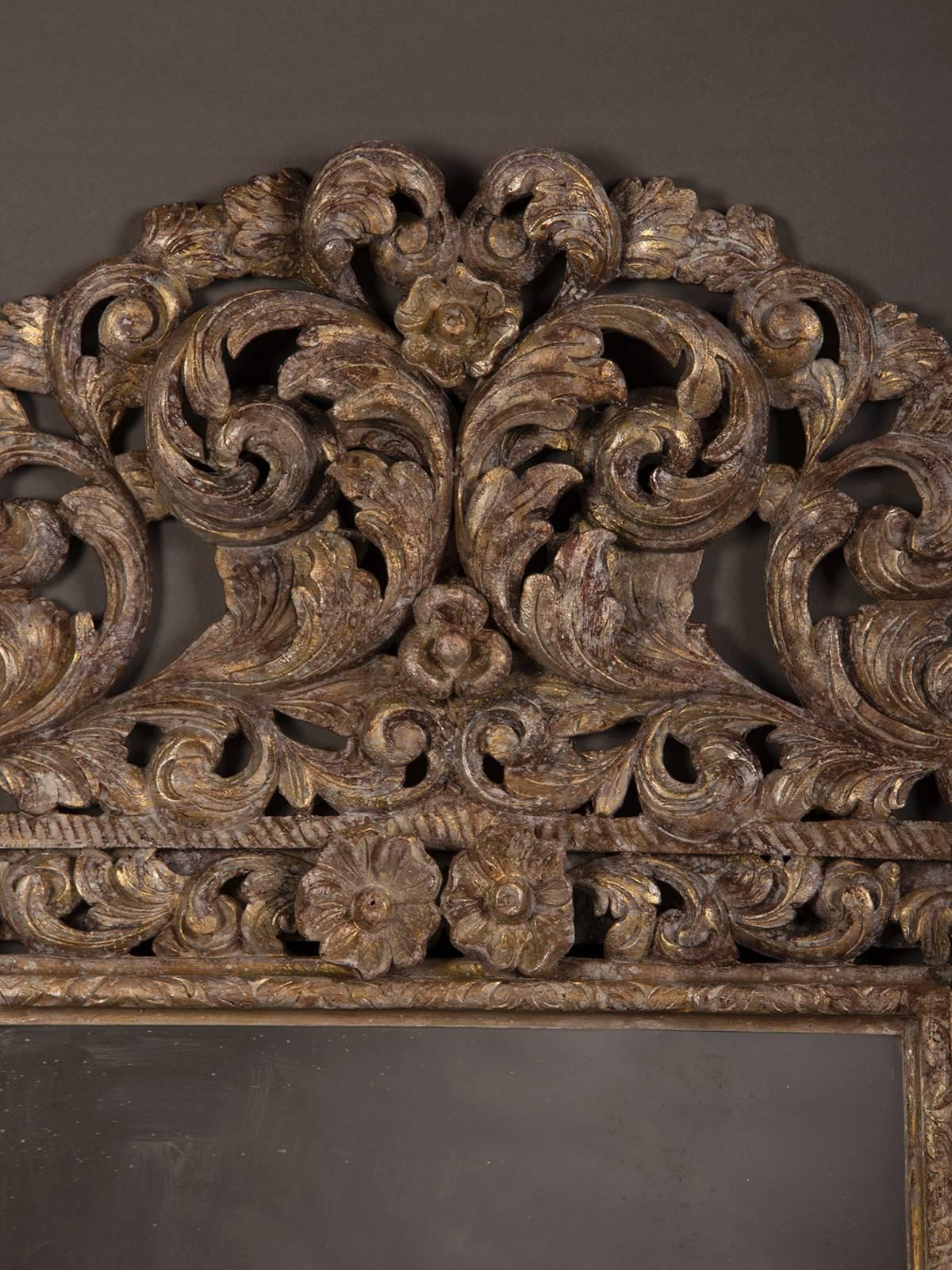 An antique English Charles II style carved and painted mirror frame circa 1880 having an elaborate carved and pierced crown with detail to the side and bottom border.